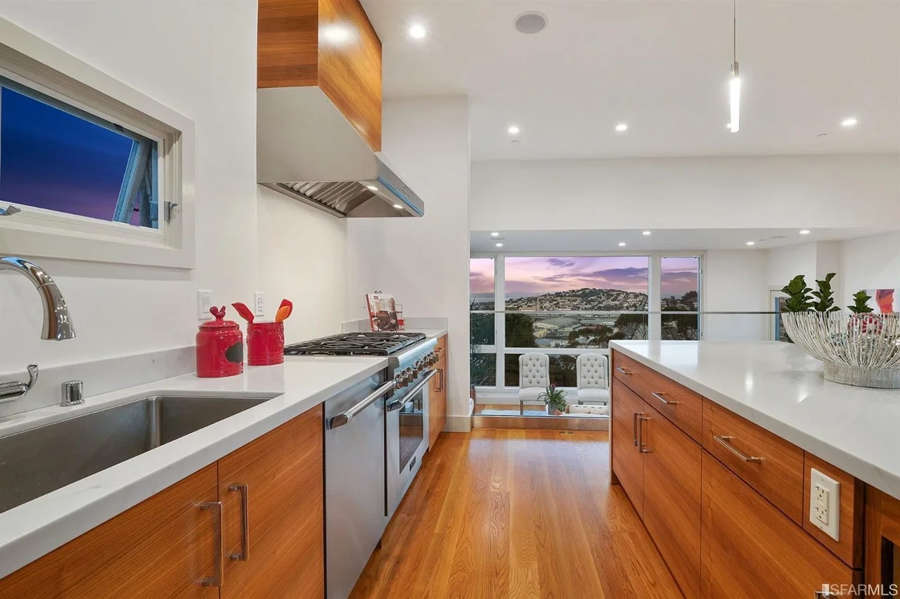 Kitchen sink area with wood cabinets and large window in home addition — San Francisco Bay Area general contractor