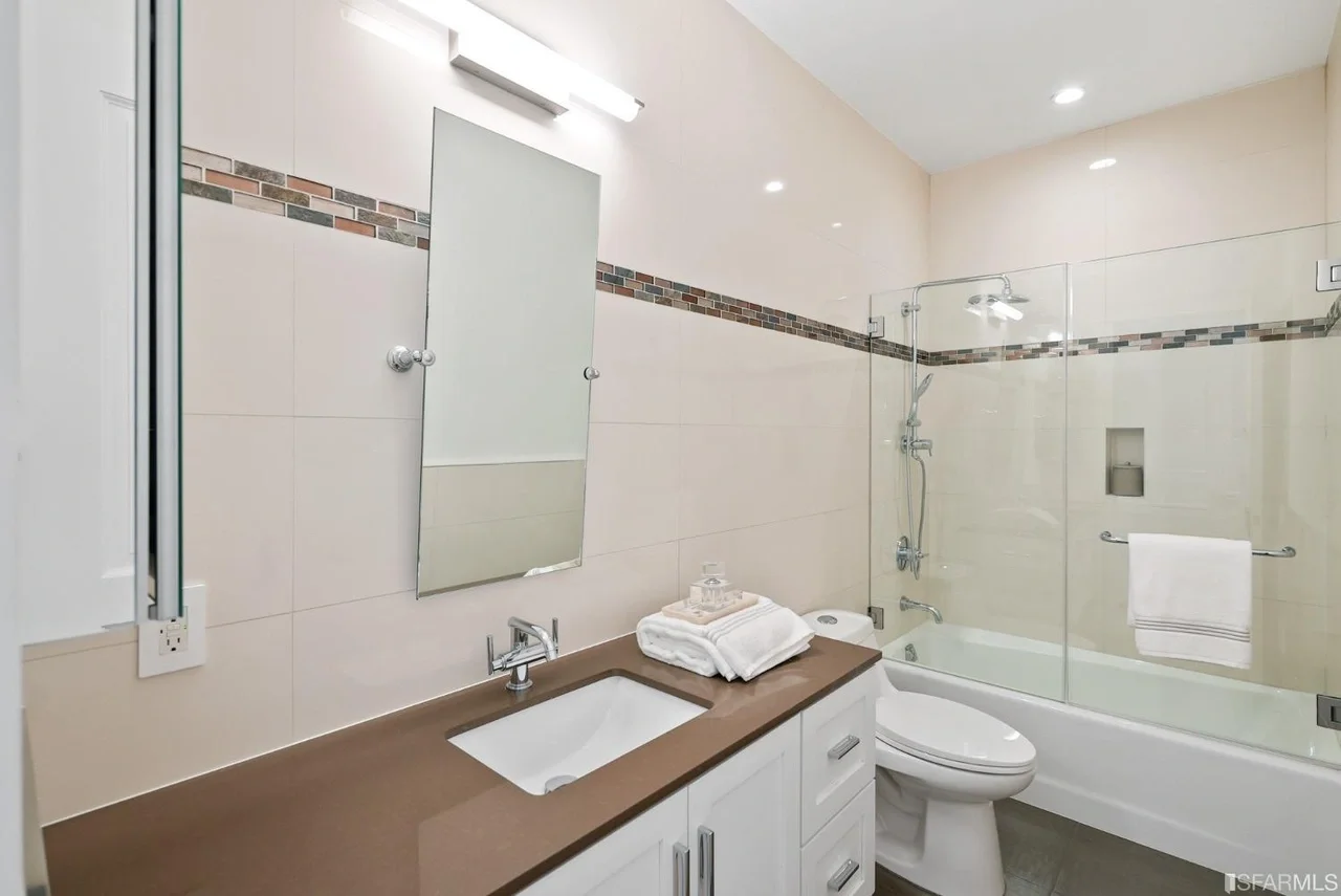 Bathroom vanity remodel with tile detail and glass shower enclosure — San Francisco Bay Area general contractor.