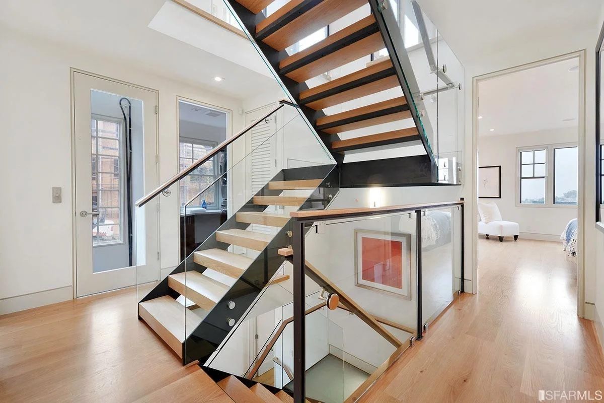 Modern open-riser staircase with wood treads and black metal railing — San Francisco Bay Area general contractor