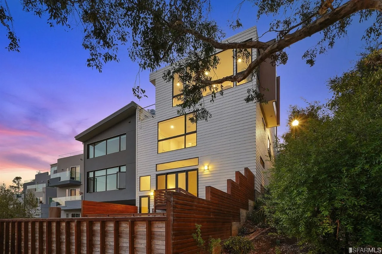 Exterior of modern home addition at dusk with wood deck railing and landscaping — San Francisco Bay Area general contractor