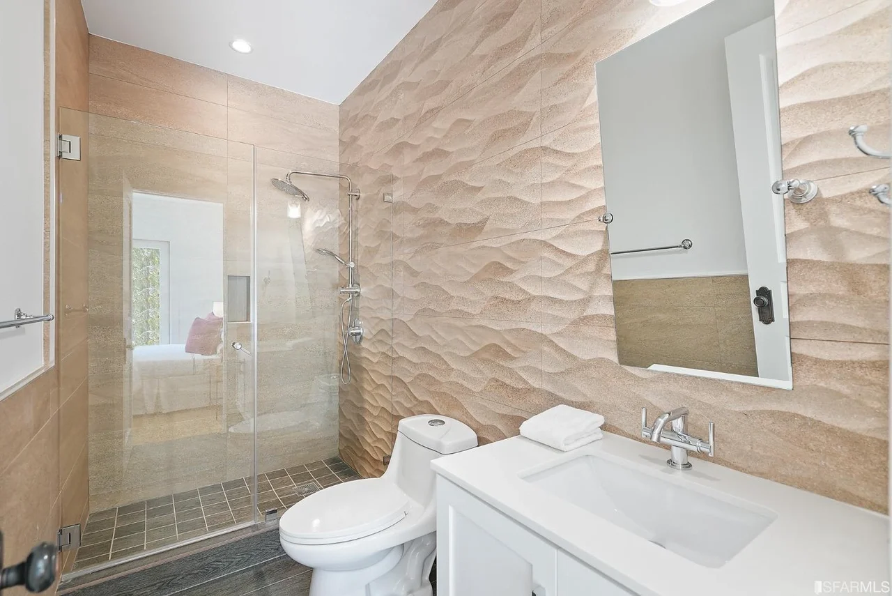 Bathroom renovation with textured stone-style tile and updated fixtures — San Francisco Bay Area general contractor.
