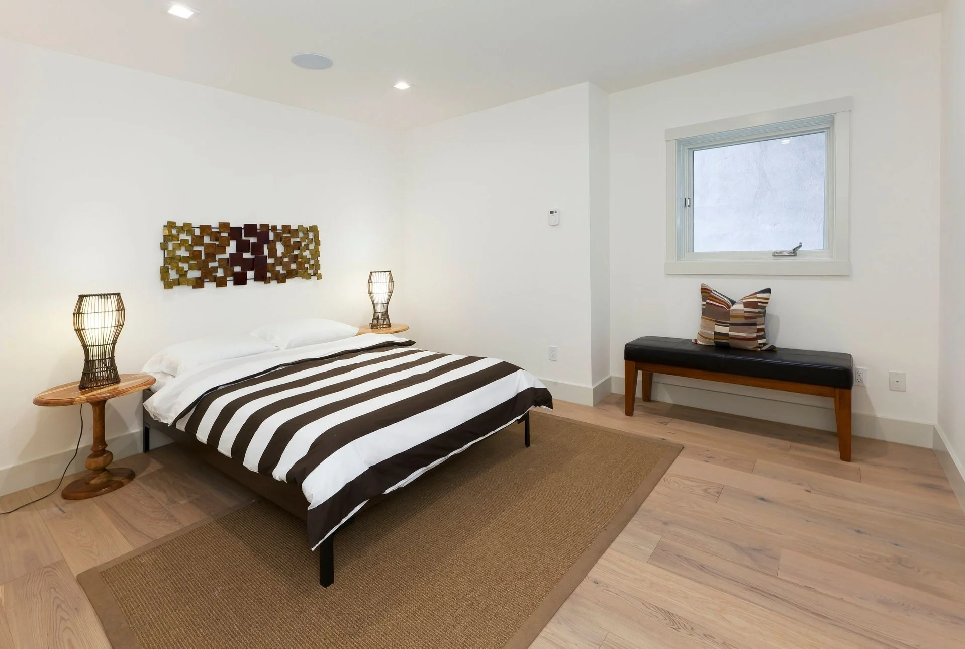 Bedroom in San Francisco Bay Area condominium renovation with wide-plank flooring and modern, clean design — general contractor
