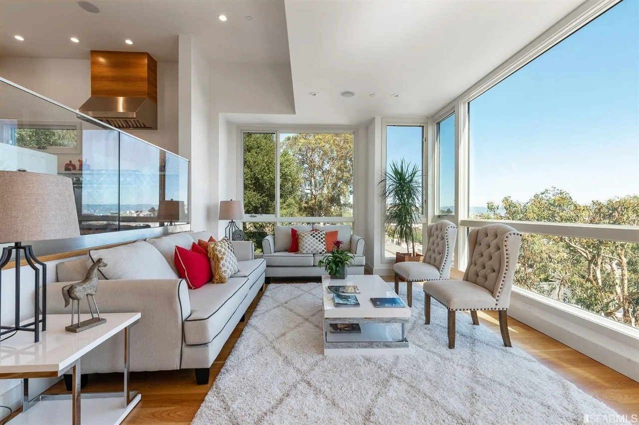 Living room in home addition with large windows, sectional seating, and hardwood floors — San Francisco Bay Area general contractor