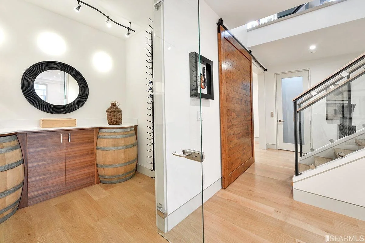 Hallway in home addition with wood accent door and wide-plank flooring — San Francisco Bay Area general contractor