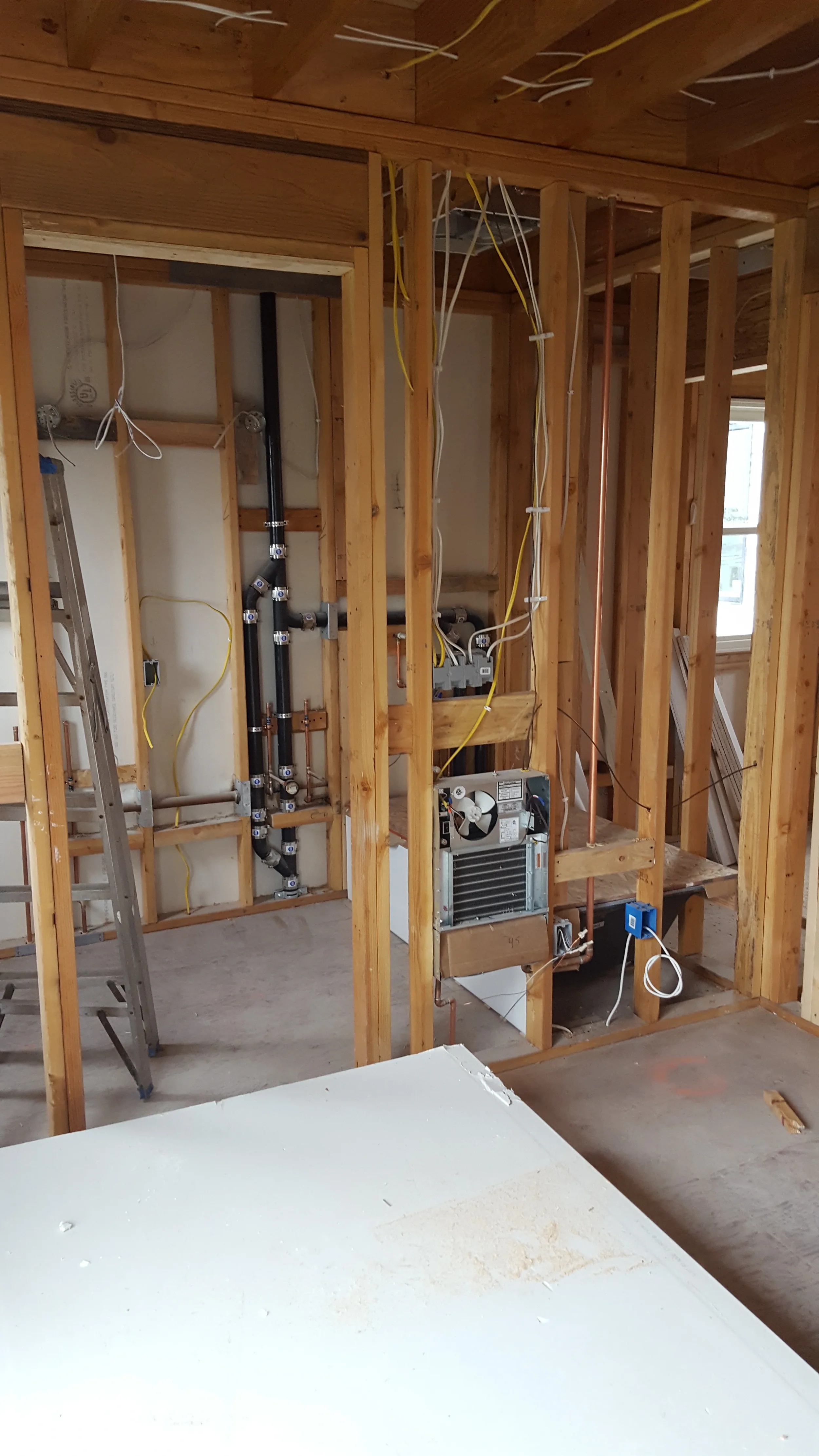 Rough-in plumbing and electrical within framed walls during condo remodel — San Francisco Bay Area general contractor