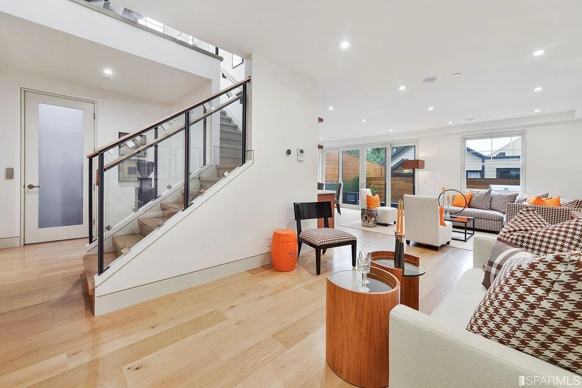 Staircase with iron railing and wood treads overlooking open living area — San Francisco Bay Area general contractor