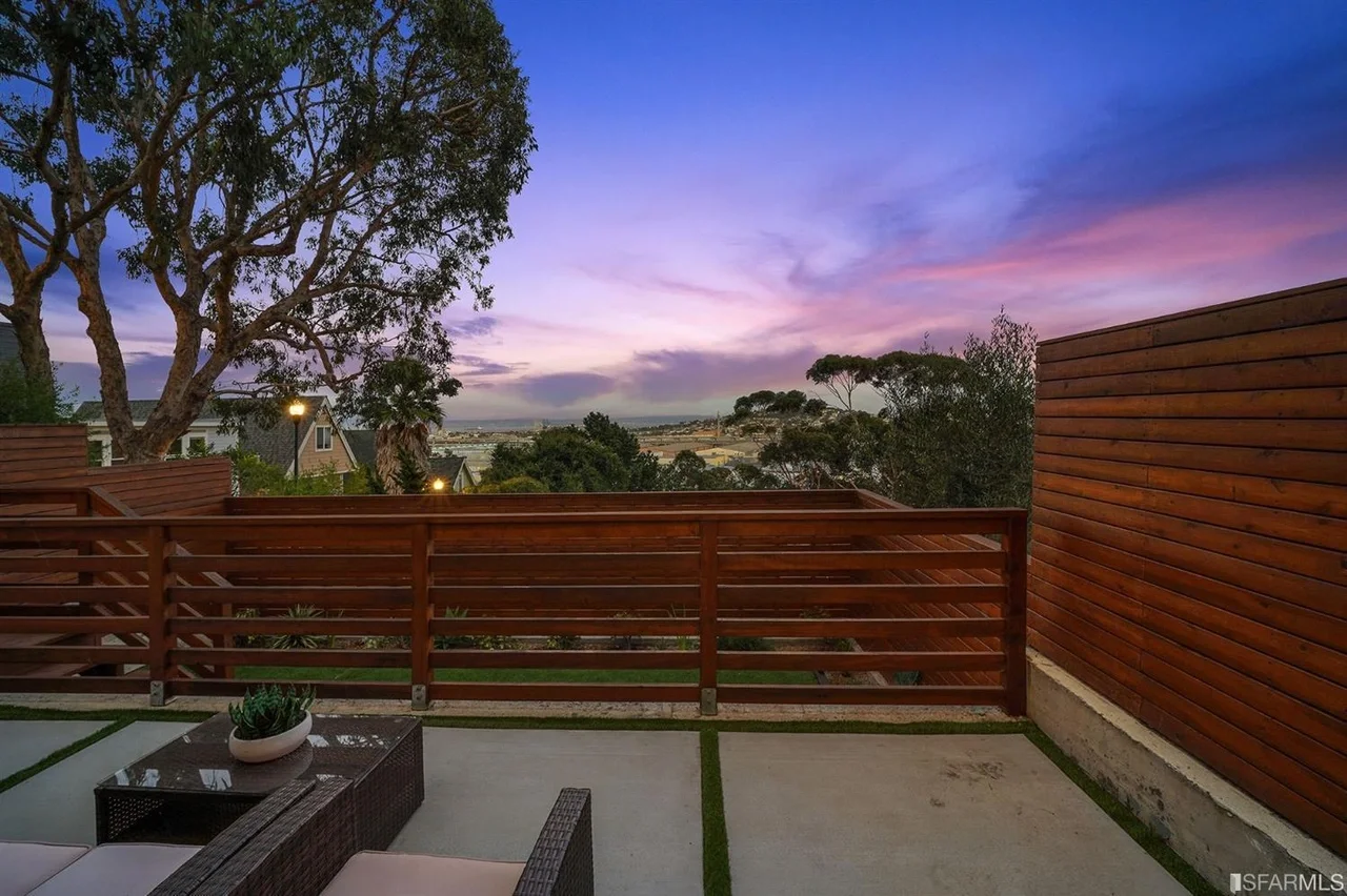 Private deck and fence at sunset behind single-family home addition — San Francisco Bay Area general contractor
