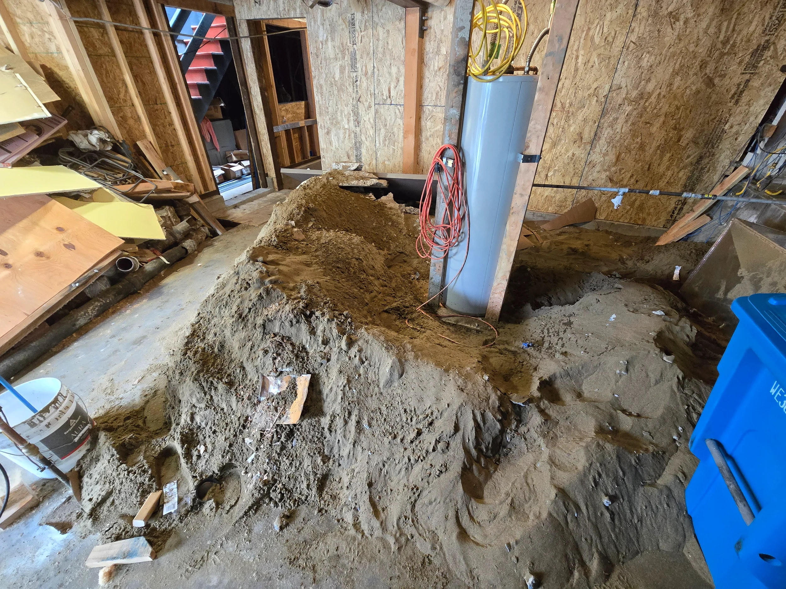 Underfloor trench and piping runs in progress for ground-floor conversion — San Francisco Bay Area general contractor