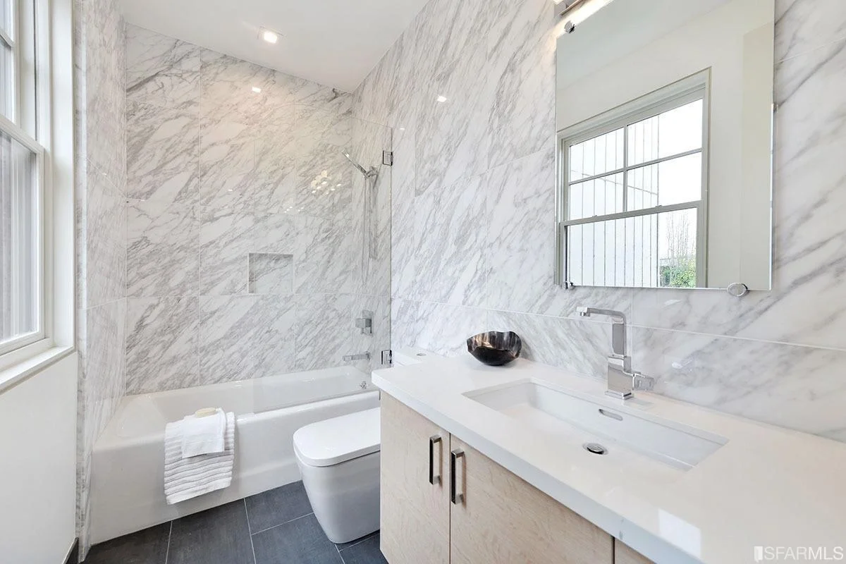 primary bathroom with marble tile, glass shower, and modern vanity — San Francisco Bay Area general contractor