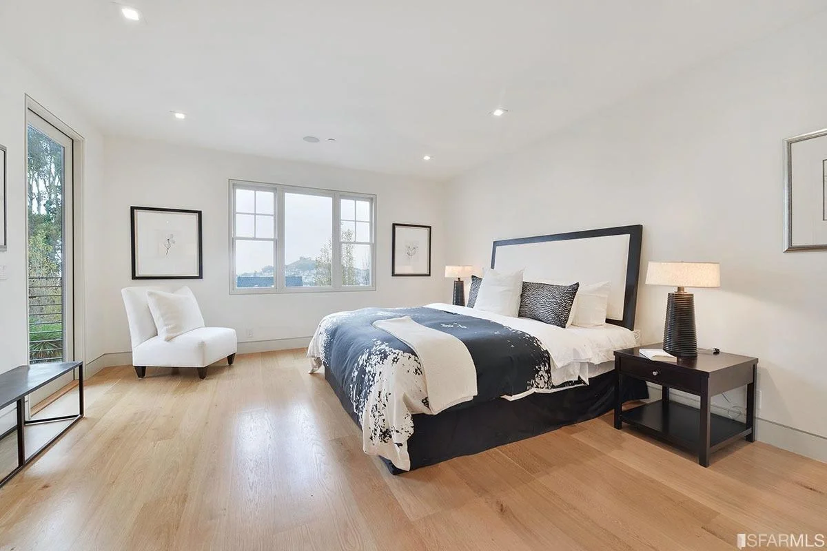Finished bedroom with wide-plank flooring, recessed lighting, and large windows — San Francisco Bay Area general contractor
