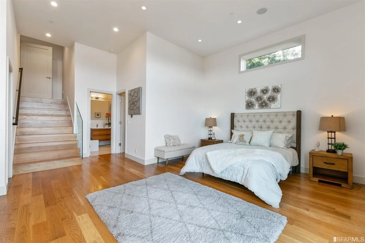 Bedroom in vertical addition with wide-plank flooring and closet doors — San Francisco Bay Area general contractor