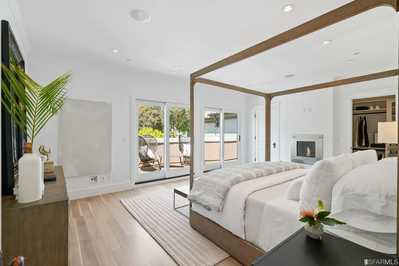 Primary bedroom renovation with canopy bed, hardwood floors, and bright windows — San Francisco Bay Area general contractor.