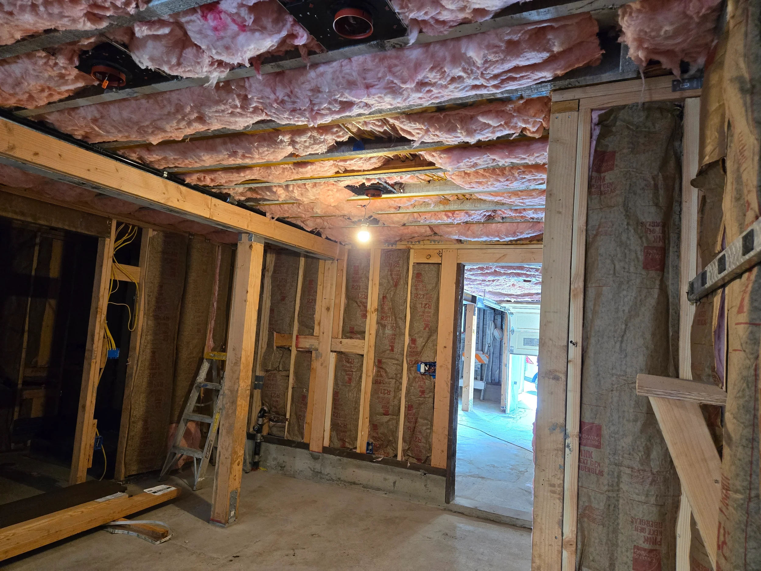 Insulation installation at underside of floor during ground-floor conversion — San Francisco Bay Area general contractor