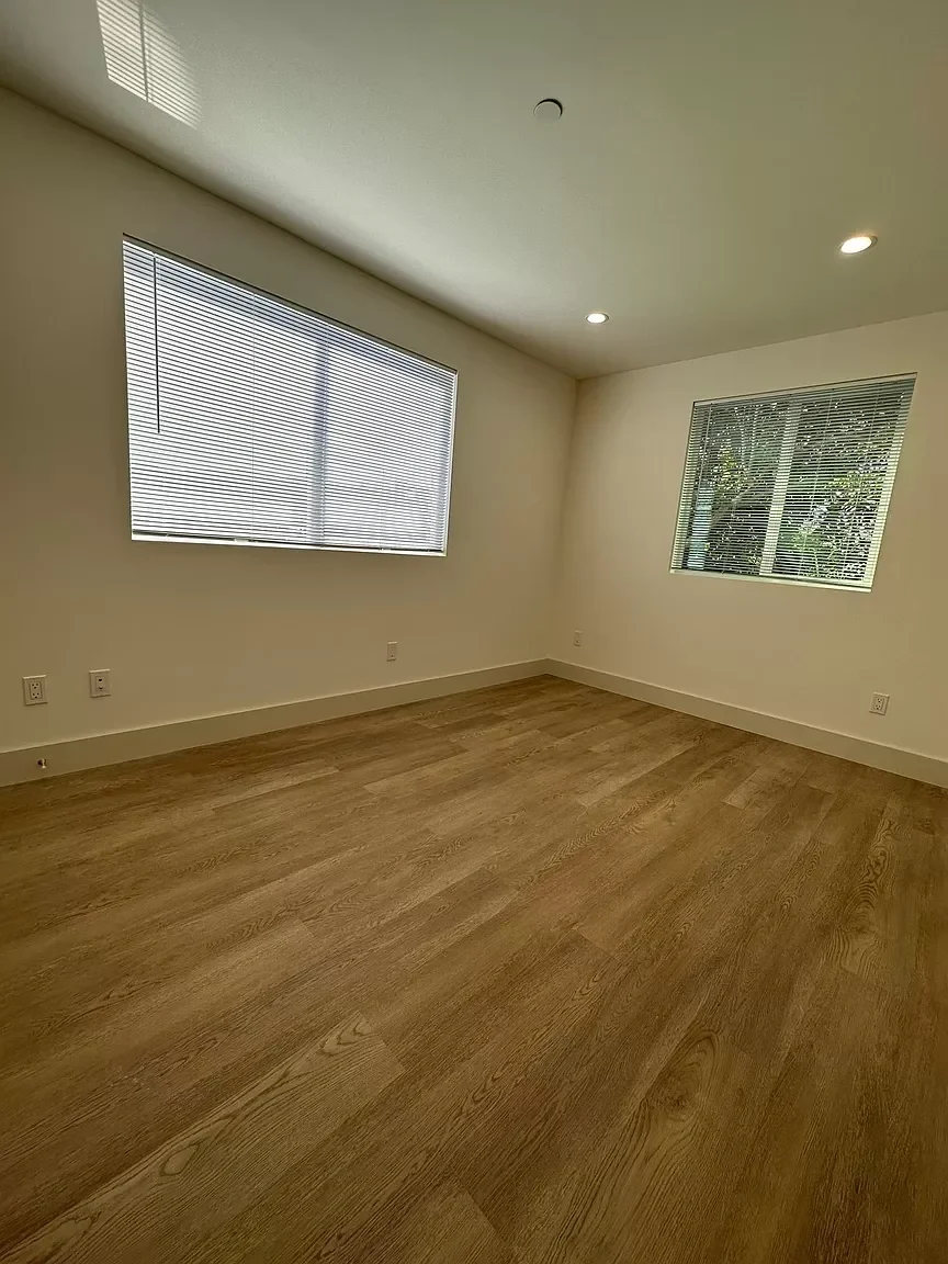 Two-story detached ADU bedroom with wide-plank flooring and large window — San Francisco Bay Area general contractor