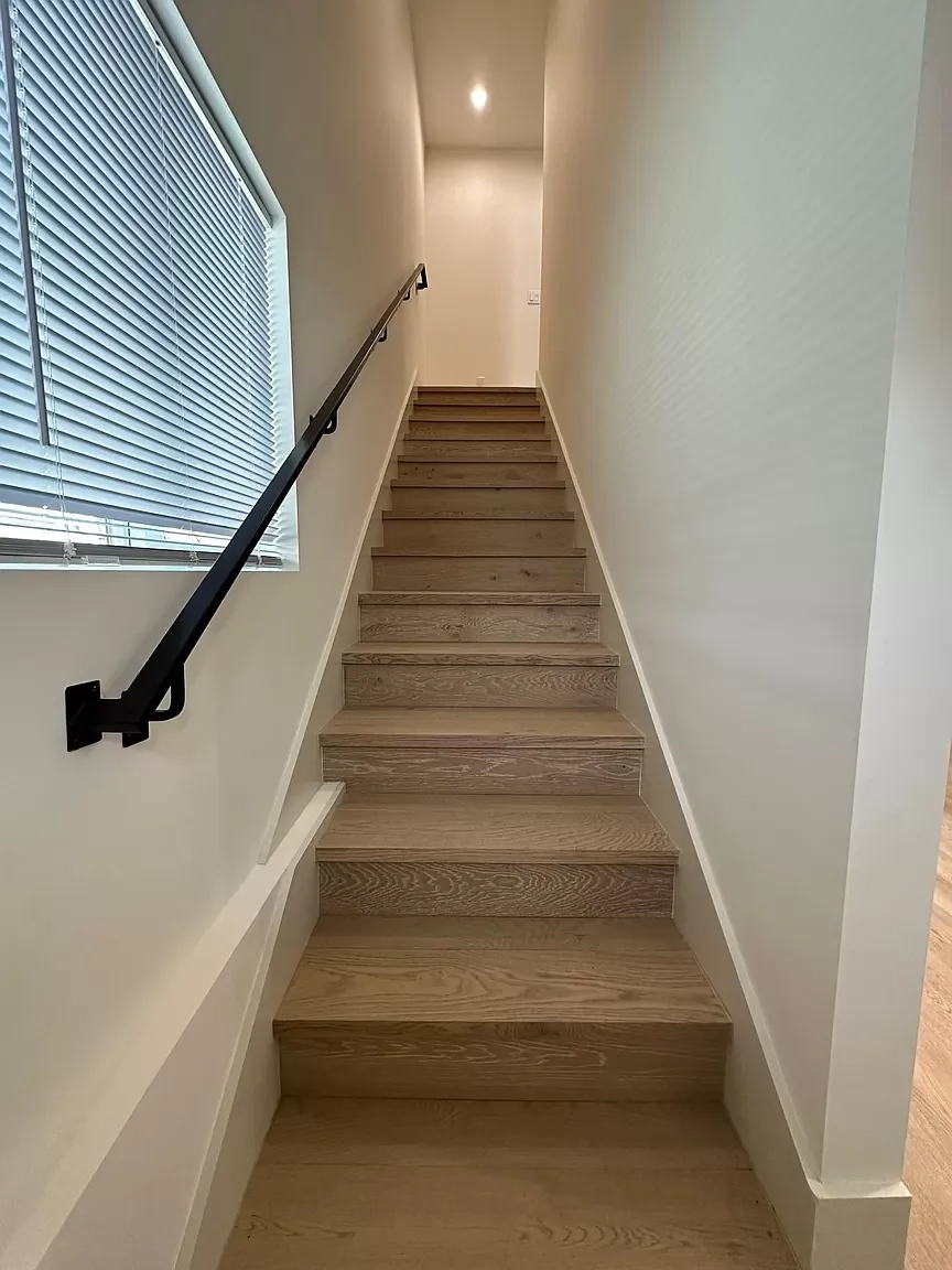 Two-story detached ADU staircase with wood treads and modern handrail — San Francisco Bay Area general contractor