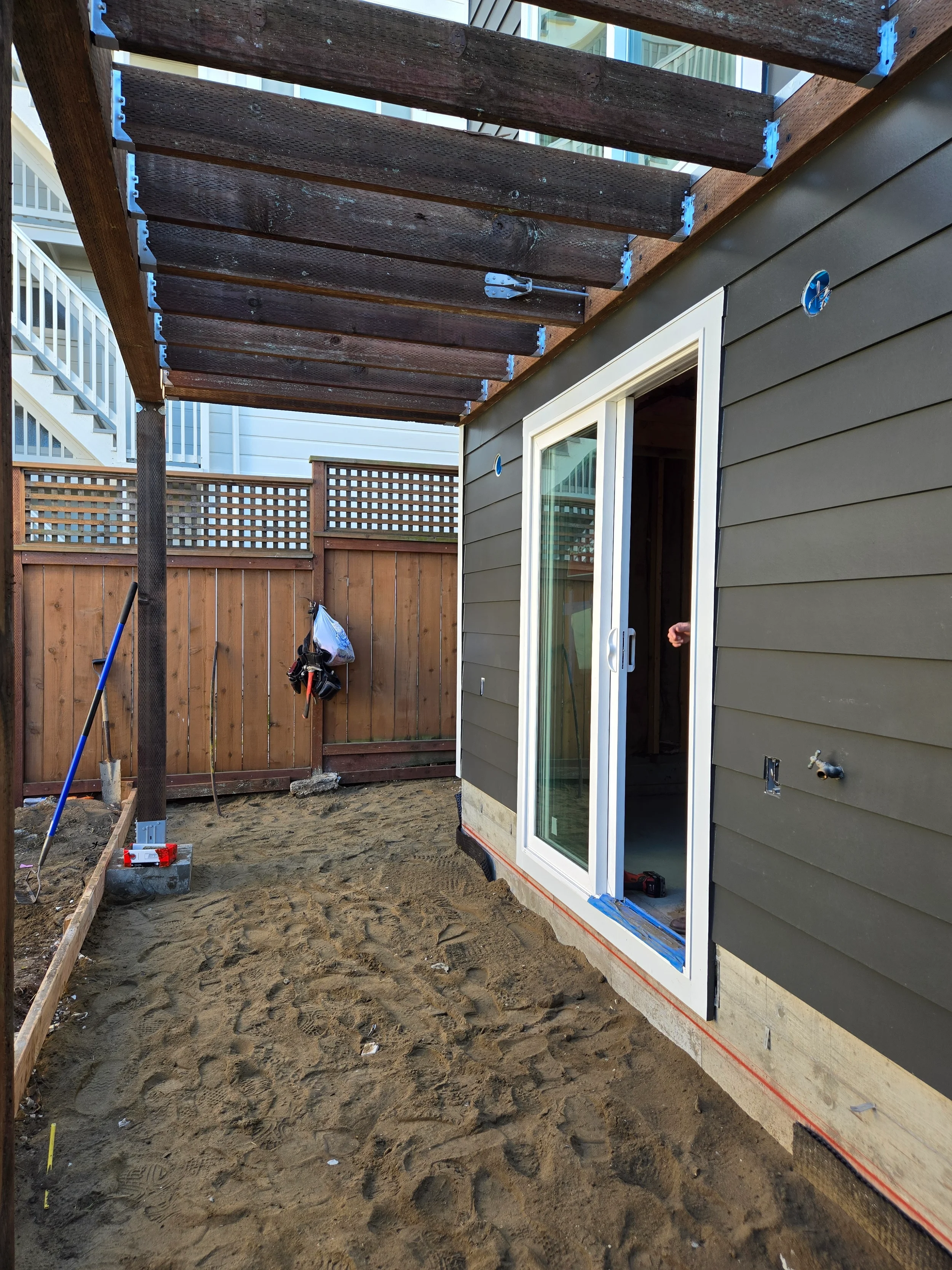 Side yard patio area in progress with new sliding door and gravel base — San Francisco Bay Area general contractor