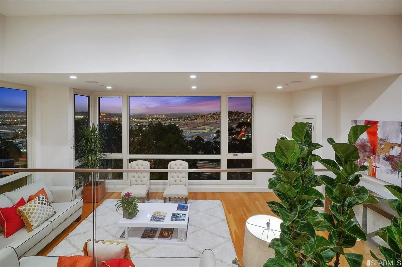 Open living and dining area at dusk with wall-to-wall windows in home addition — San Francisco Bay Area general contractor