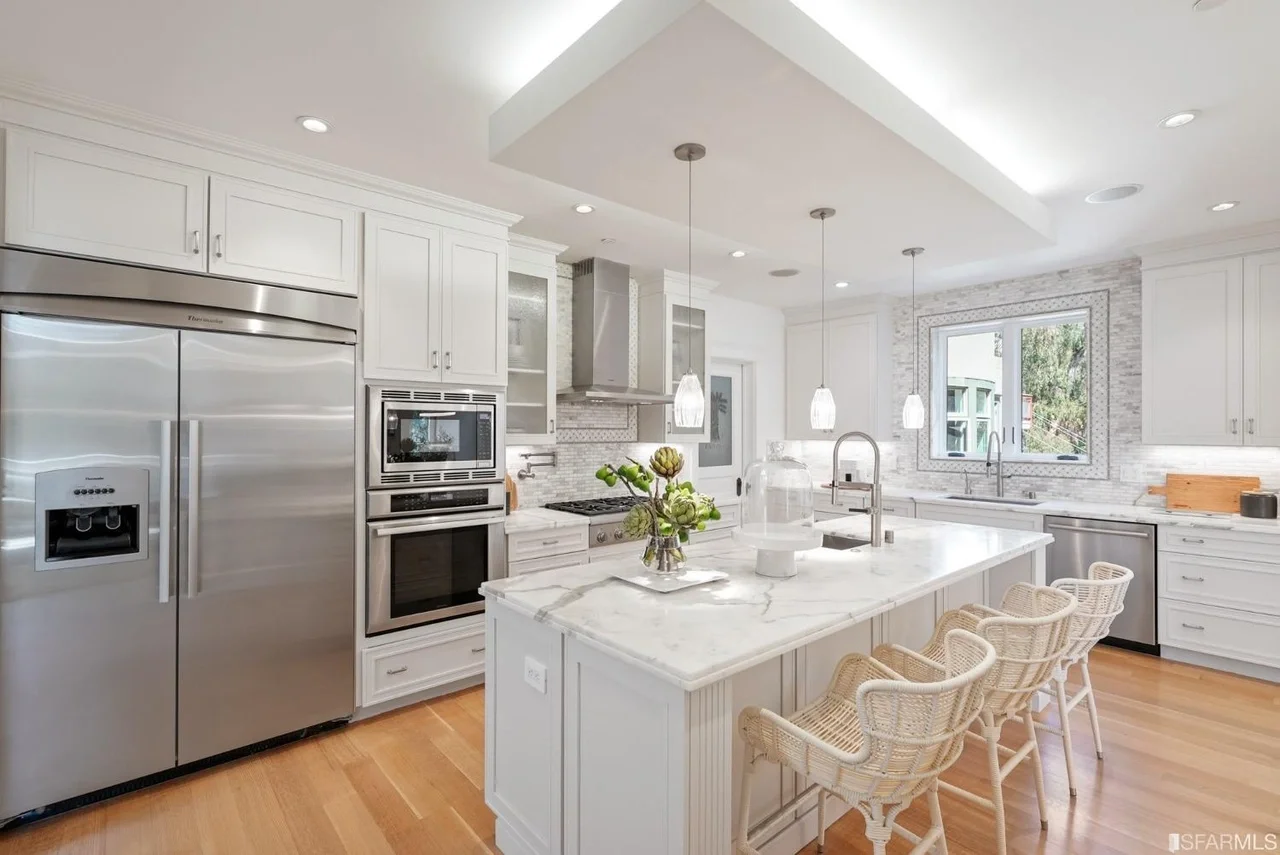 Modern kitchen remodel with white cabinetry, large island, and bright recessed lighting, white kitchen renovation with large island and recessed lighting — San Francisco Bay Area general contractor.