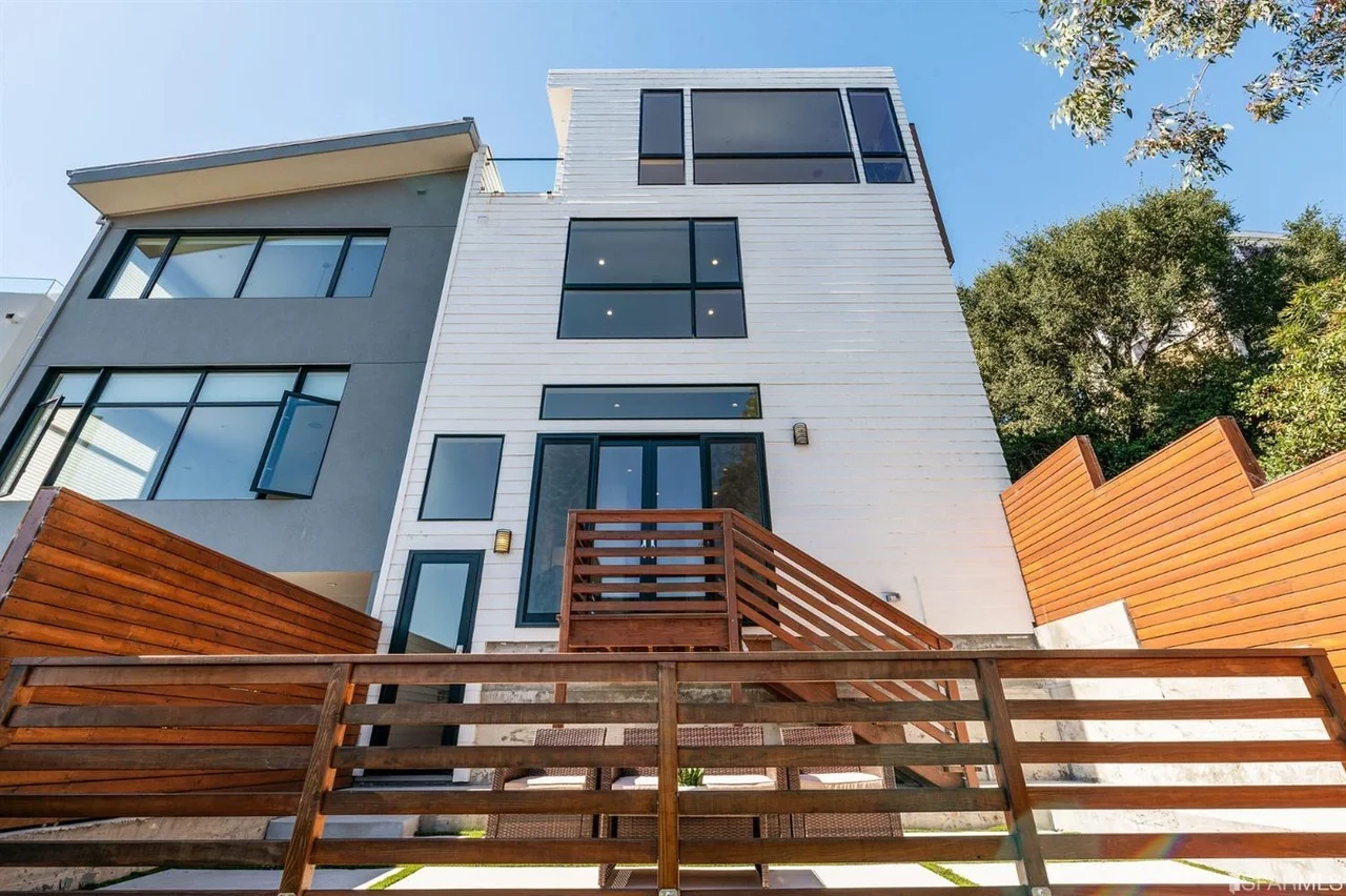 Rear exterior view of vertical home addition with updated siding and deck stairs — San Francisco Bay Area general contractor
