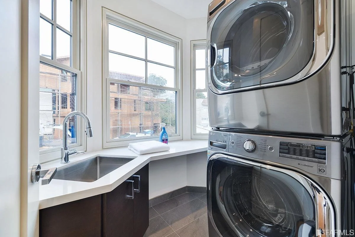 laundry room with stacked washer and dryer and natural light — San Francisco Bay Area general contractor