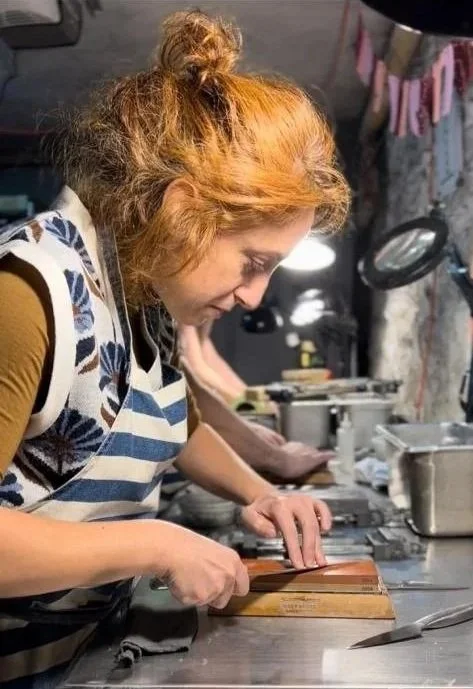 Student sharpening a knife on a whetstone
