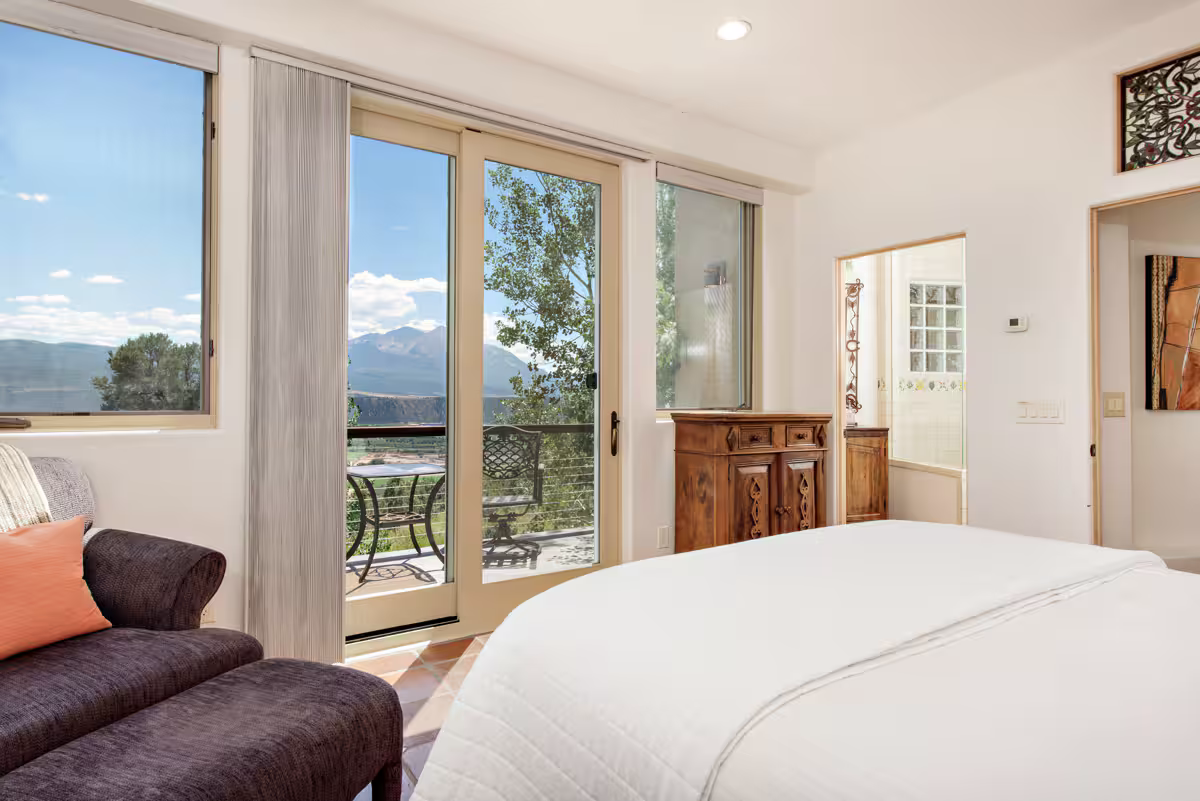 Guesthouse - guest bedroom with queen bed, sitting area, walk out balcony, and en suite bathroom 2.png