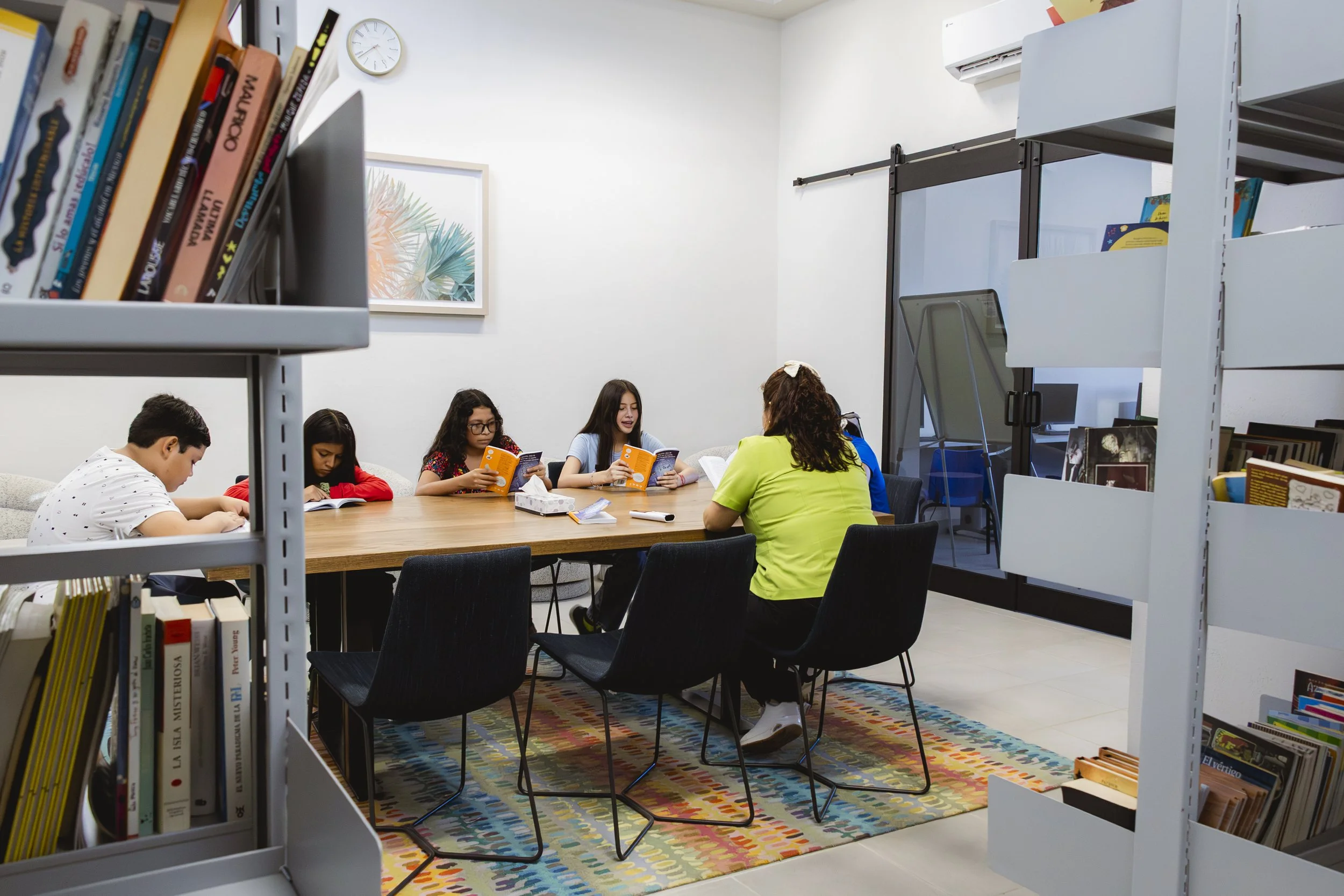Students doing out loud reading in the Liga MAC Library (second floor) at Spanish Tutoring Class