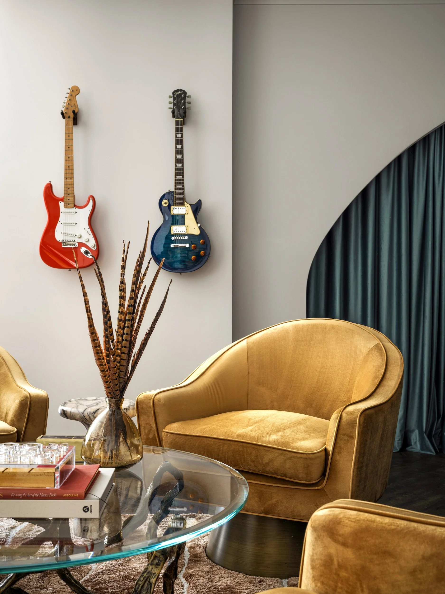 Music lounge with mounted guitars, gold velvet chairs, and teal drapery, designed by Luxe Style Studio