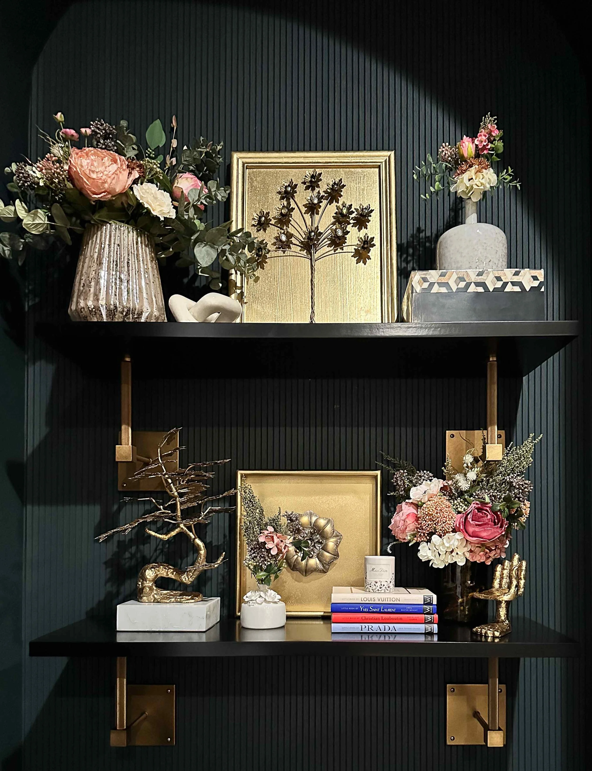 East Cobb luxury living room dark fluted shelves styled with gold botanical art, brass sculpture, pink florals, and fashion coffee table books, East Cobb, GA private residence, interior design by Luxe Style Studio