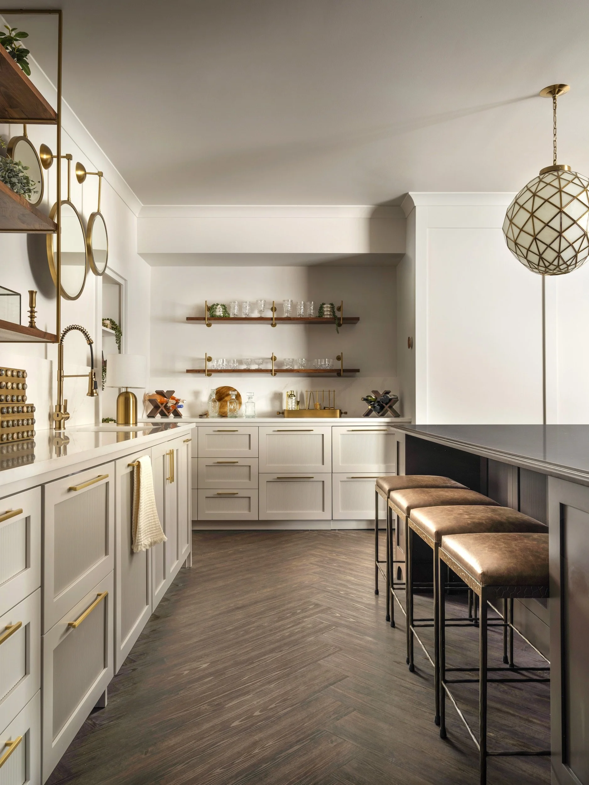 Completed Franklin bar with fluted cabinetry, brass hardware, open shelving, leather stools, and herringbone flooring, designed by Luxe Style Studio