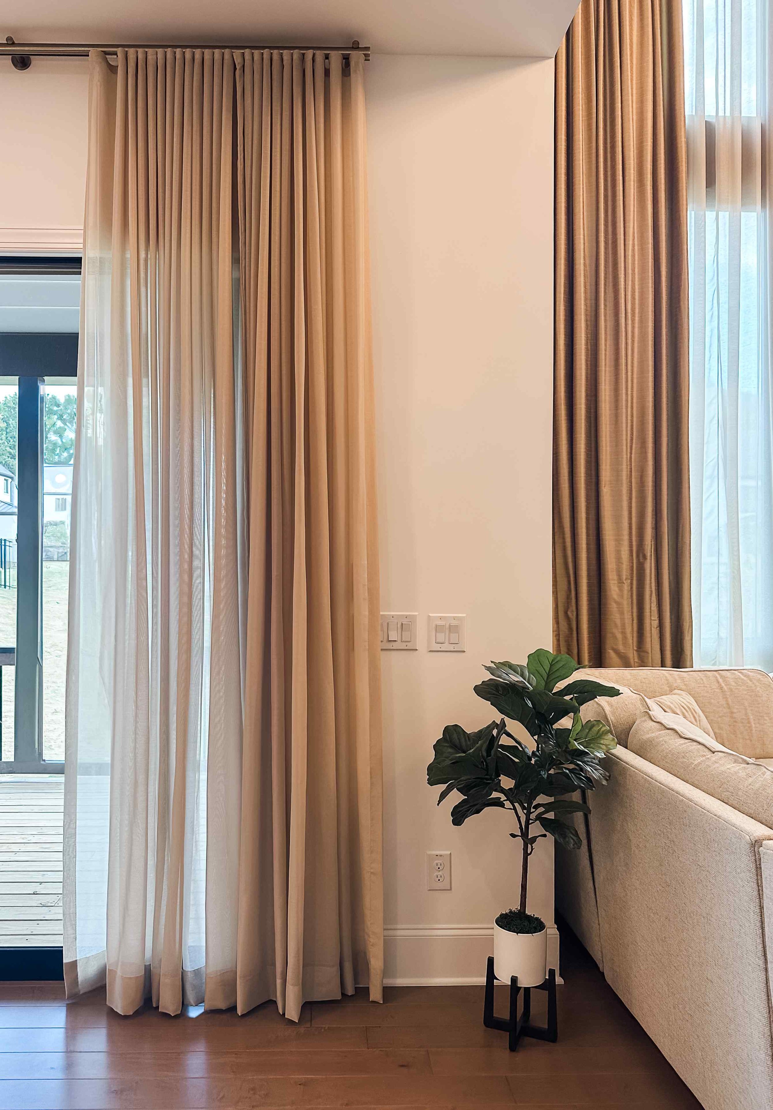 Floor-to-ceiling layered linen drapes with white sheer curtains styled by Luxe Style Studio interior design
