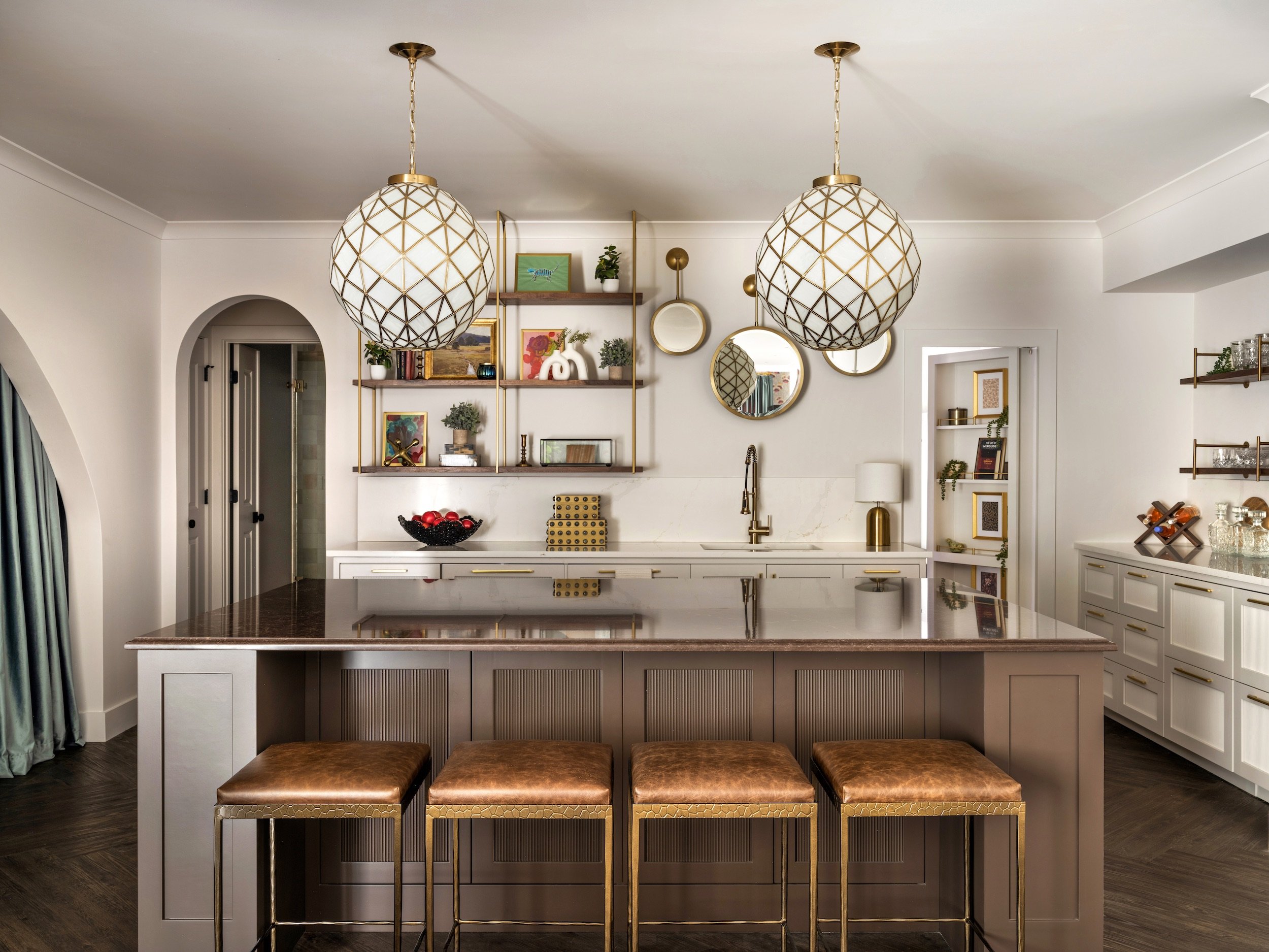 Hidden Murphy door concealed in the kitchen millwork beside the fluted taupe island and brass lattice globe pendants,  Atlanta, GA private residence, interior design by Luxe Style Studio