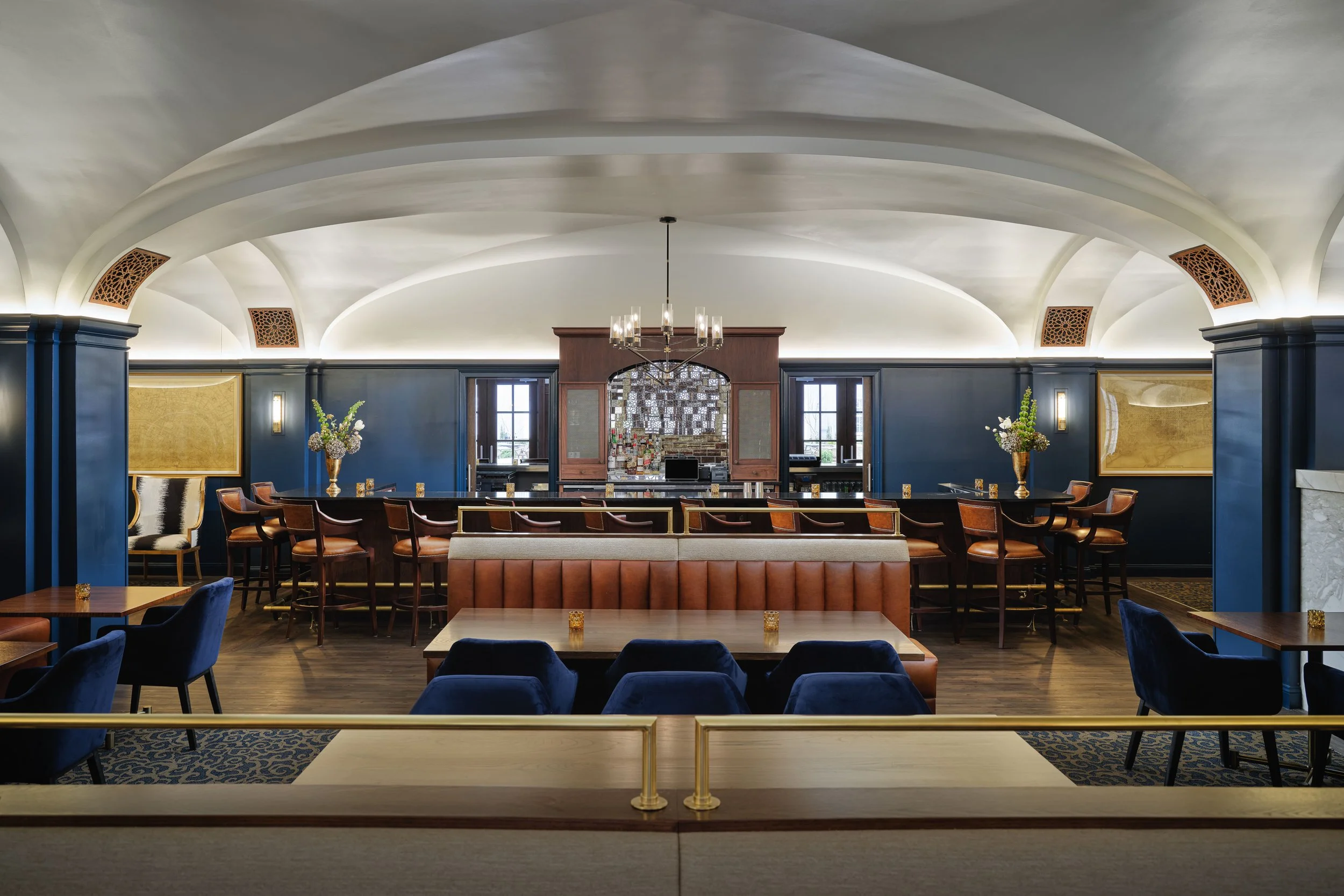 Off The Rails restaurant and bar with a groin-vaulted ceiling, cognac leather seating, navy velvet chairs, and a dark wood bar, interior design by Ashley Schneider