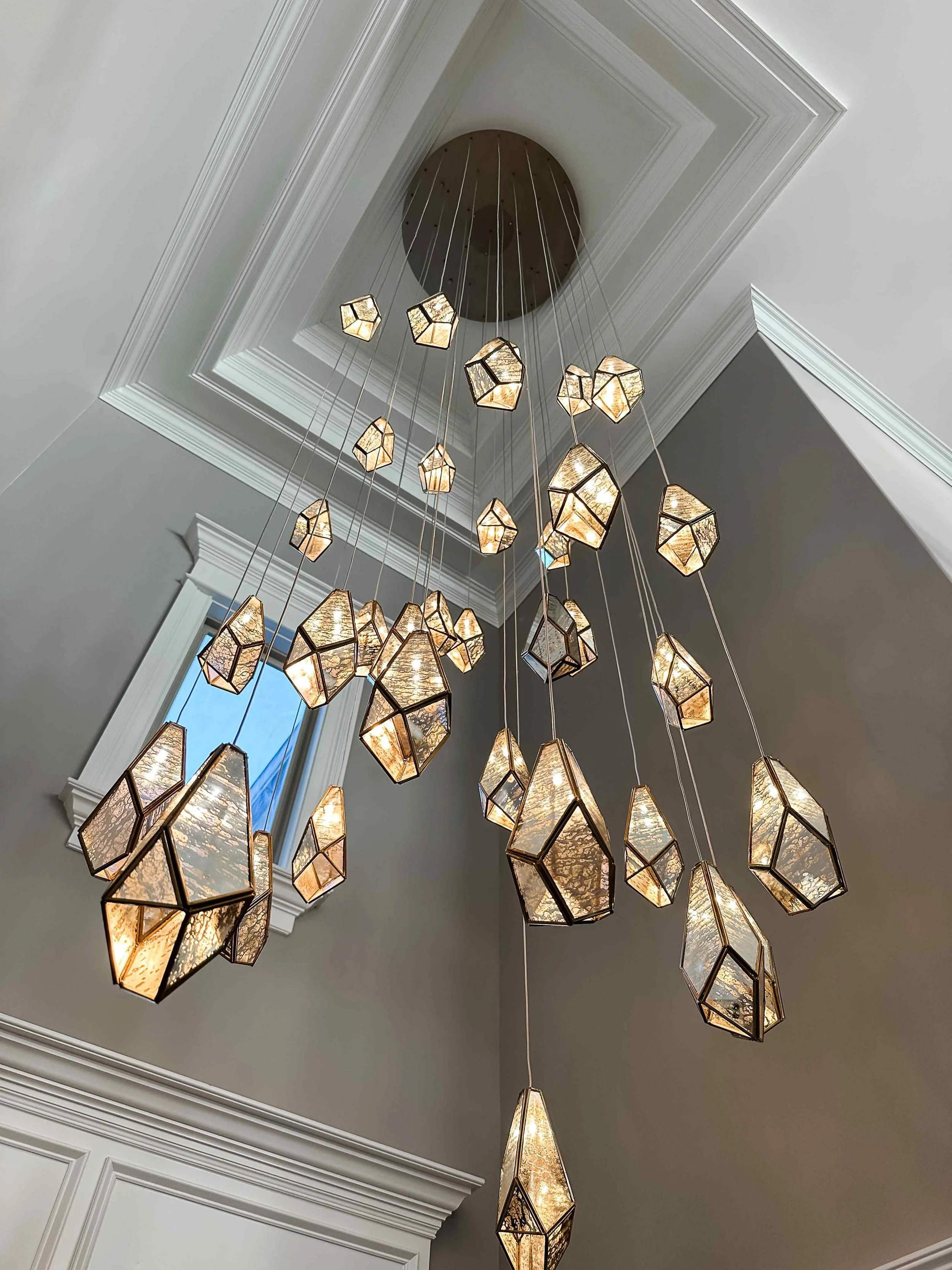 East Cobb luxury foyer with dramatic multi-pendant geometric gem chandelier cascading from coffered ceiling, East Cobb, GA private residence, interior design by Luxe Style Studio