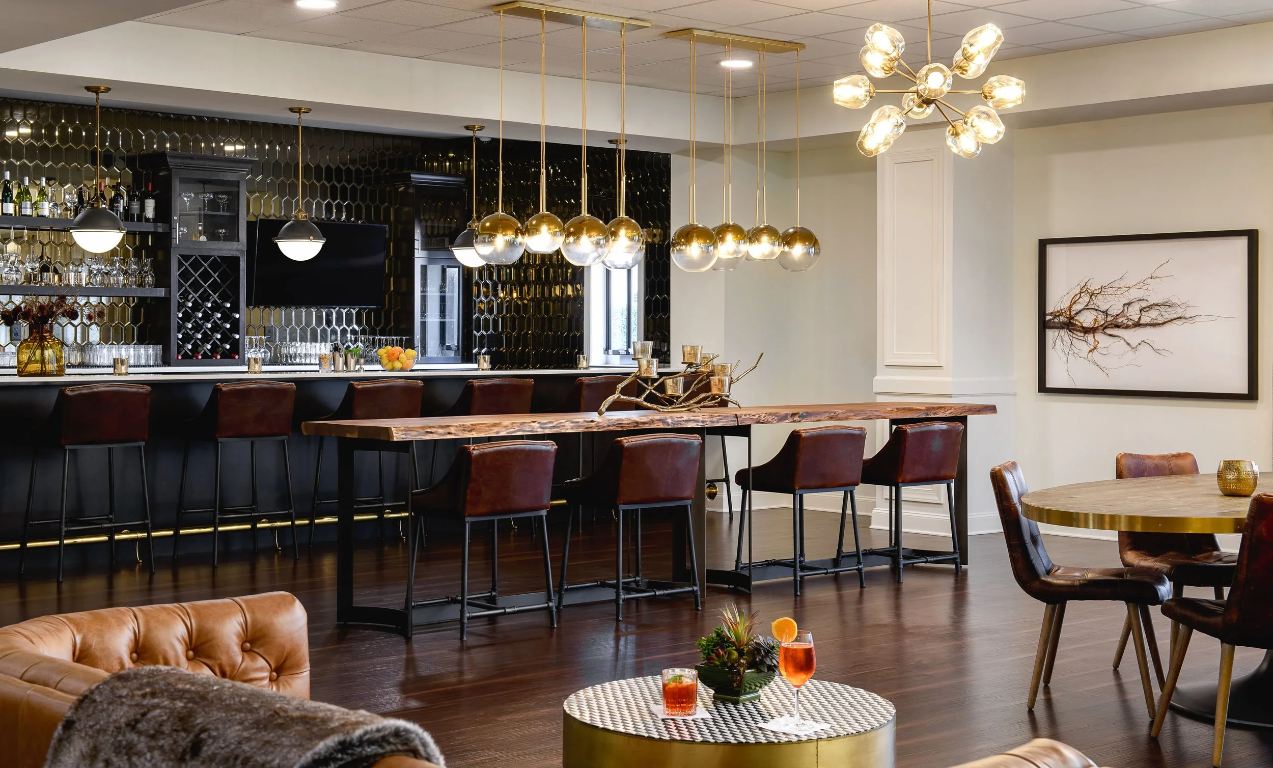 Local Hearth bar and lounge with black honeycomb tile backsplash, live edge community table, cognac leather bar stools, and cascading brass globe pendants, Acworth, GA, interior design by Ashley Schneider