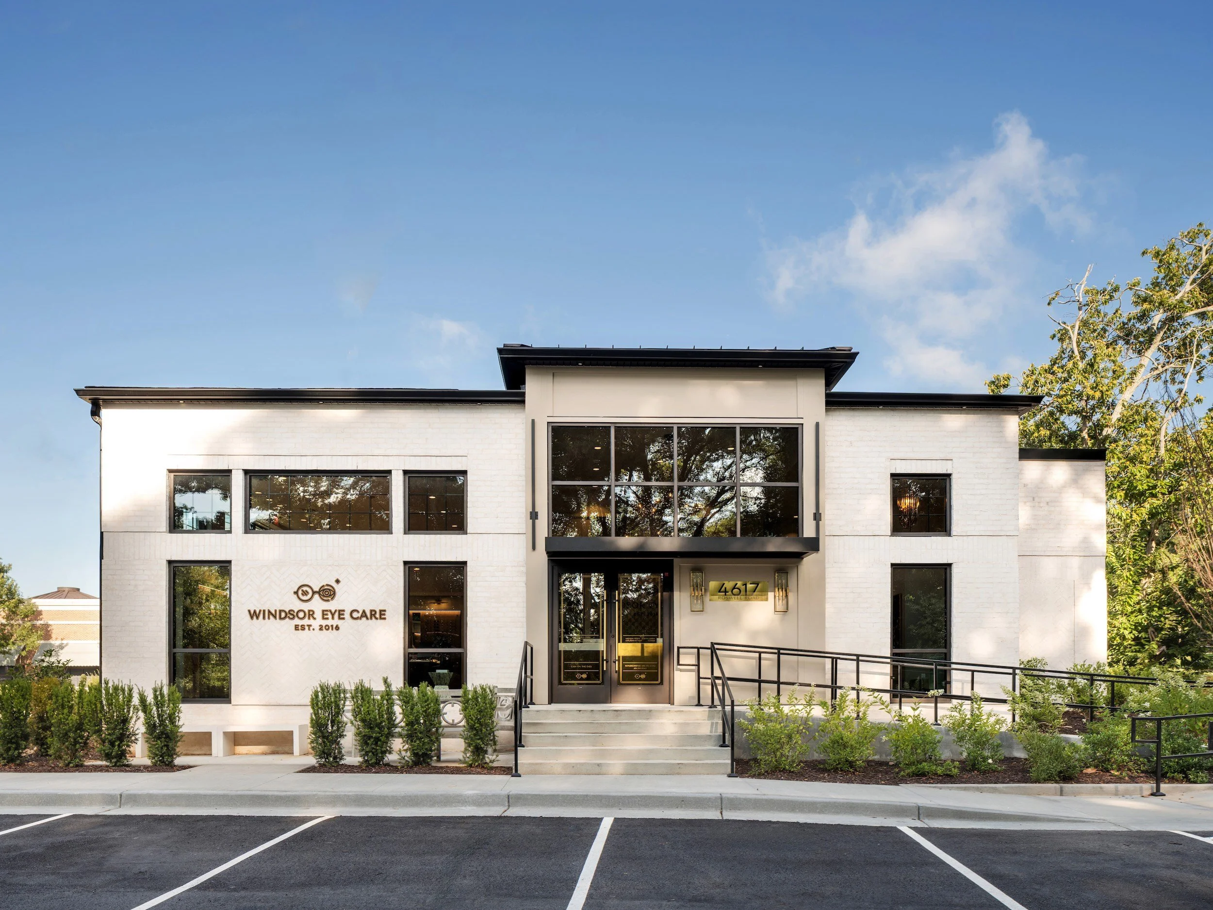White brick Windsor Eye Care exterior with tall black-framed windows, designed by Luxe Style Studio