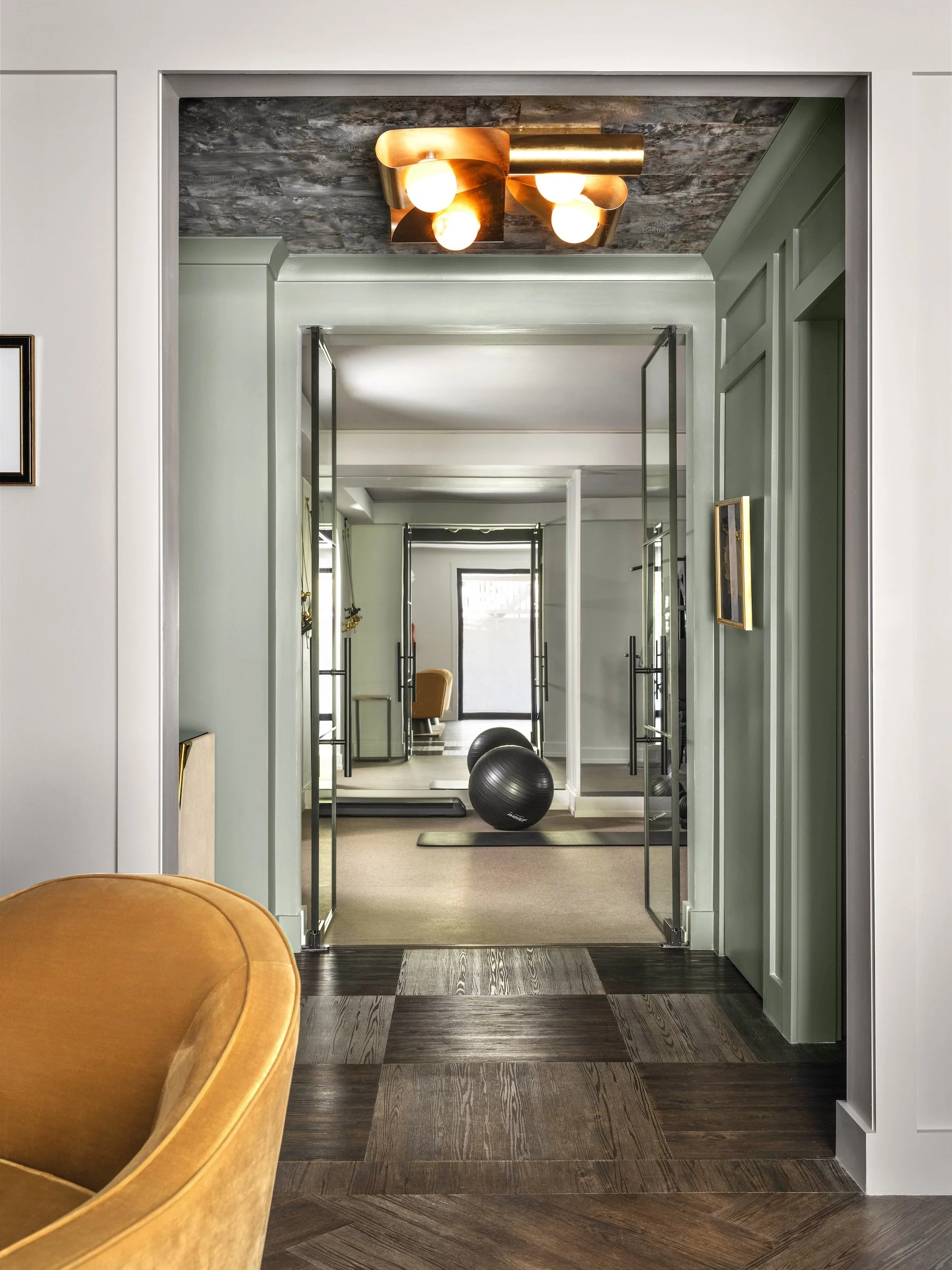 Sage green millwork doorway leading into the Franklin home gym, designed by Luxe Style Studio