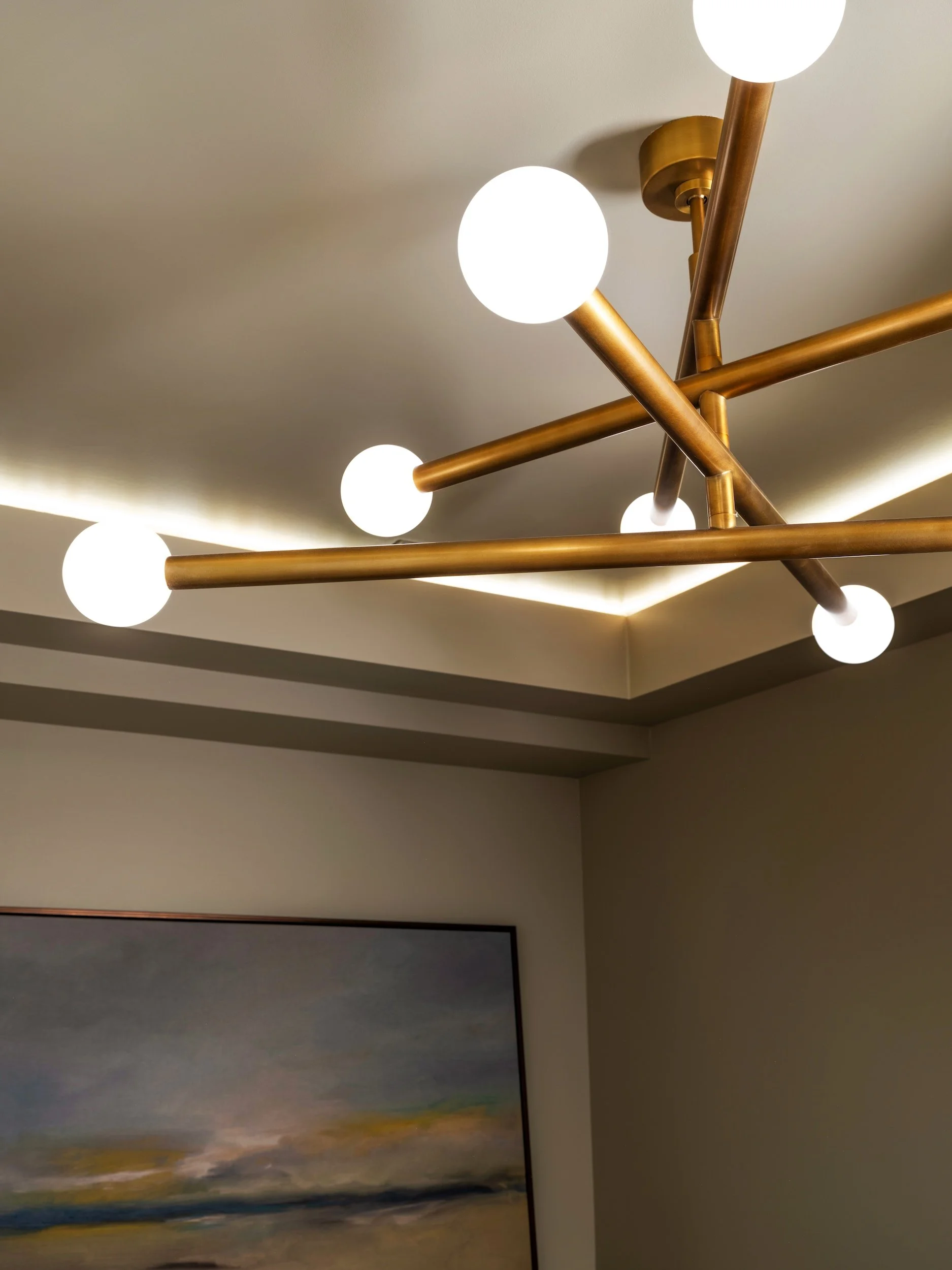Close-up detail of brass sputnik chandelier with globe bulbs and LED cove ceiling lighting in moody sitting room, Atlanta, GA private residence, interior design by Luxe Style Studio