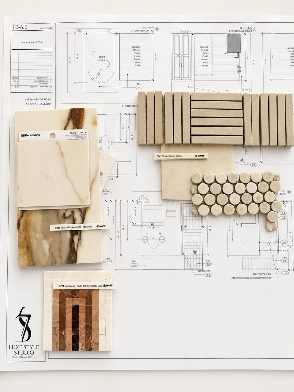 Tile and stone finish samples arranged over residential construction plans, designed by Luxe Style Studio