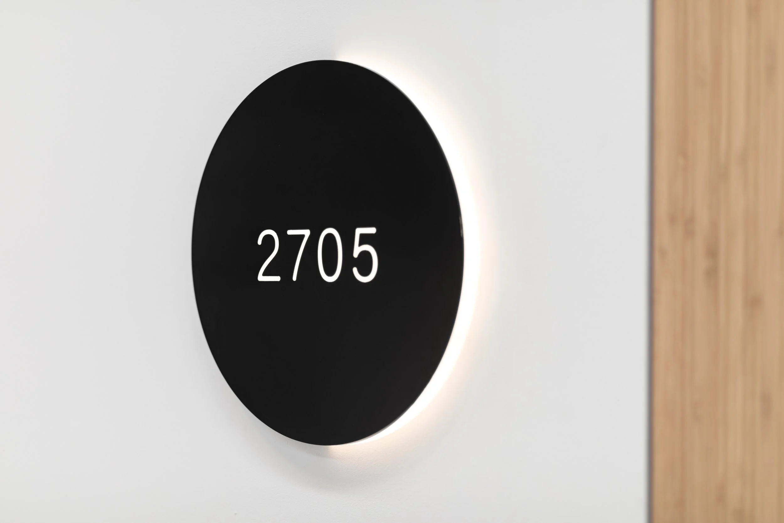 Luna is a wayfinding scheme inspired by the motion of the moon crossing the path of the sun in a solar eclipse. LED illumination on one side of the main room signs is used to indicate the direction of travel, with subtle strokes of illumination used