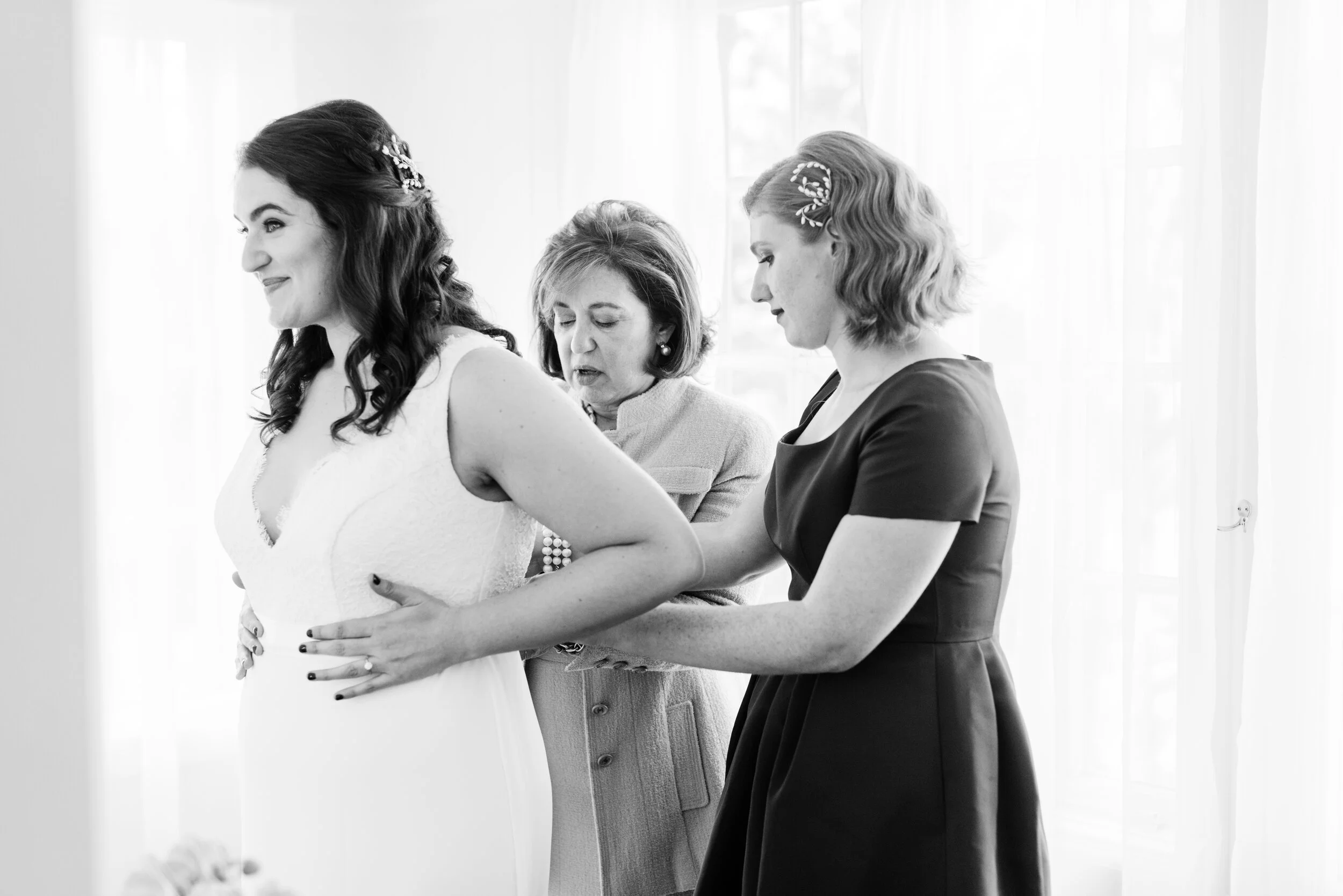 Los Angeles bride as she gets into her dress with mother of the bride and maid of honor