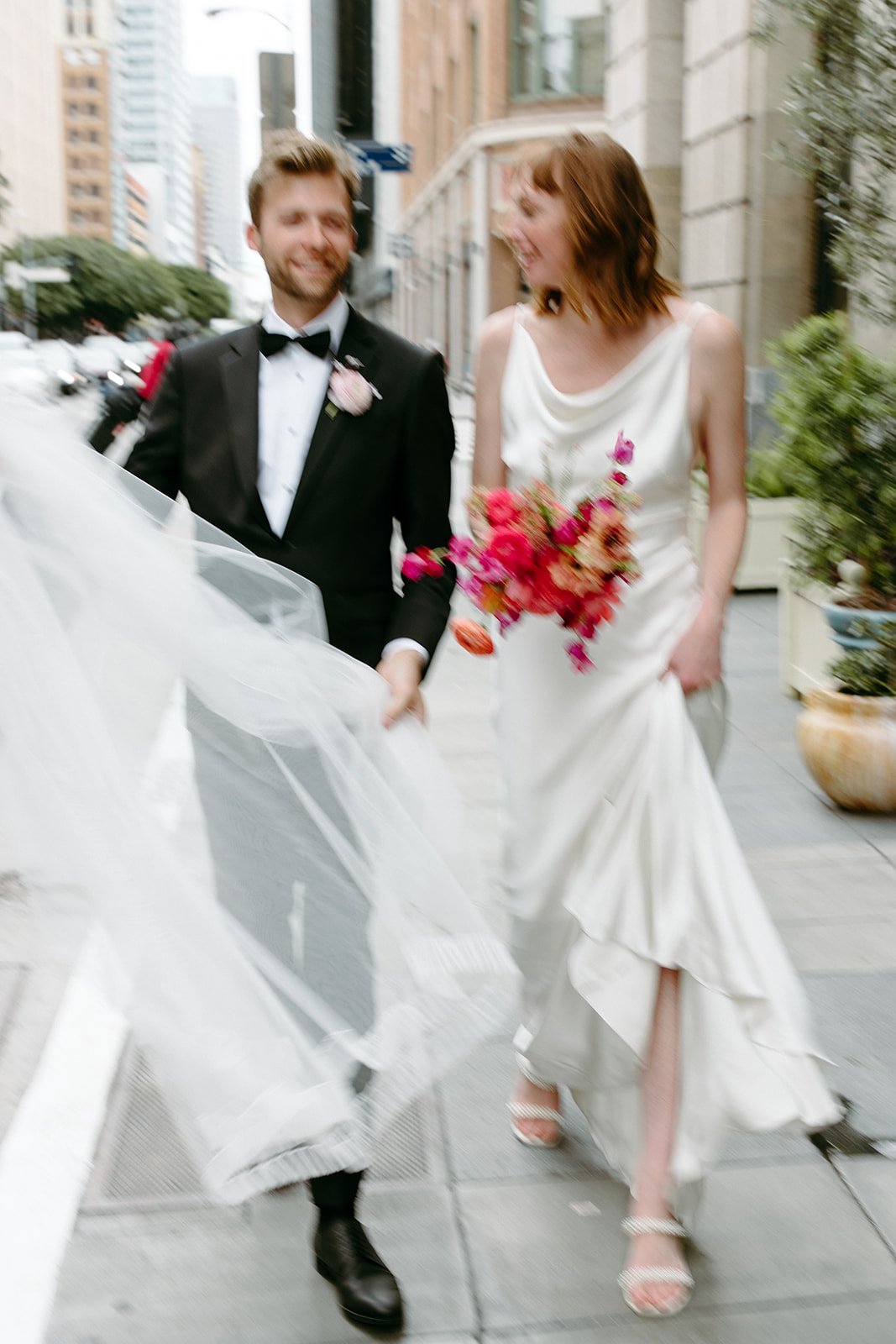 bride and groom walk through downtown LA on their wedding day
