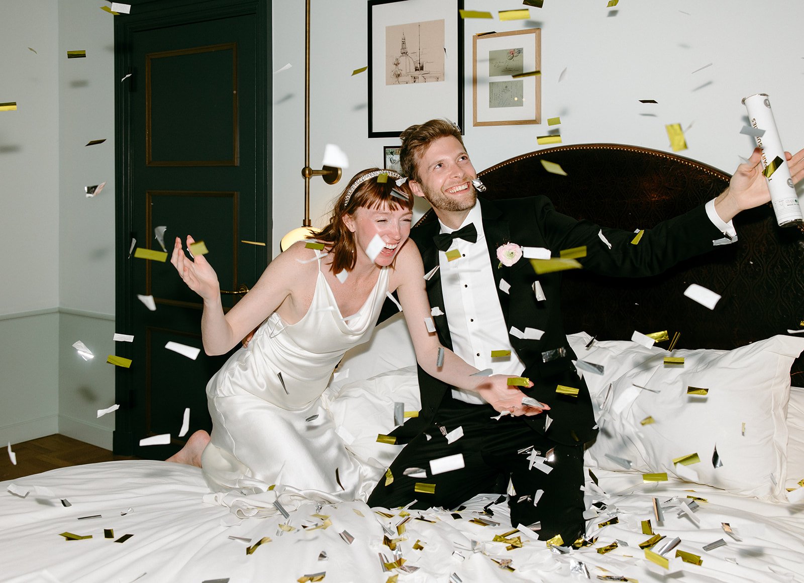 bride and groom throw confetti around their hotel room