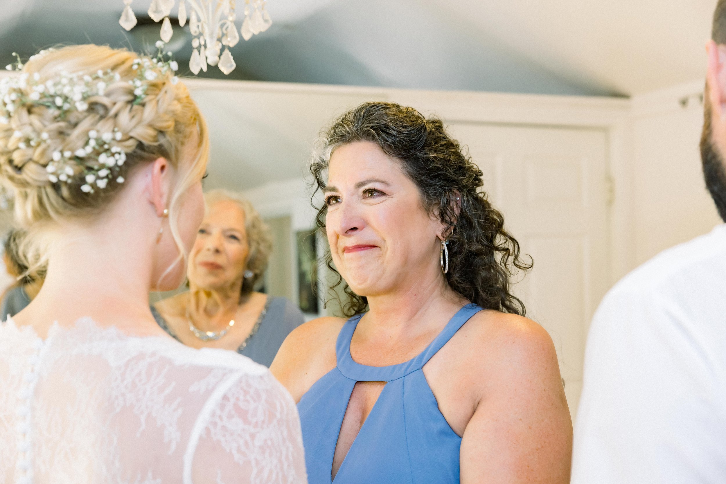 mother of the bride gets emotional when her daughter puts on her wedding dress