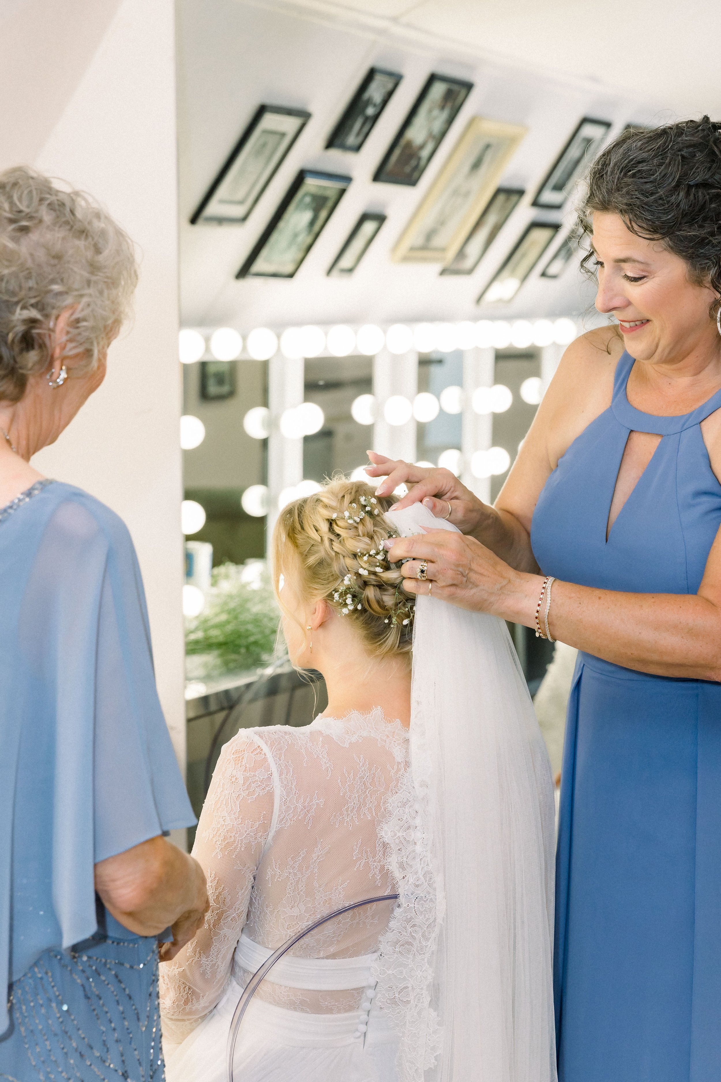 mother of the bride attaches the veil on wedding day