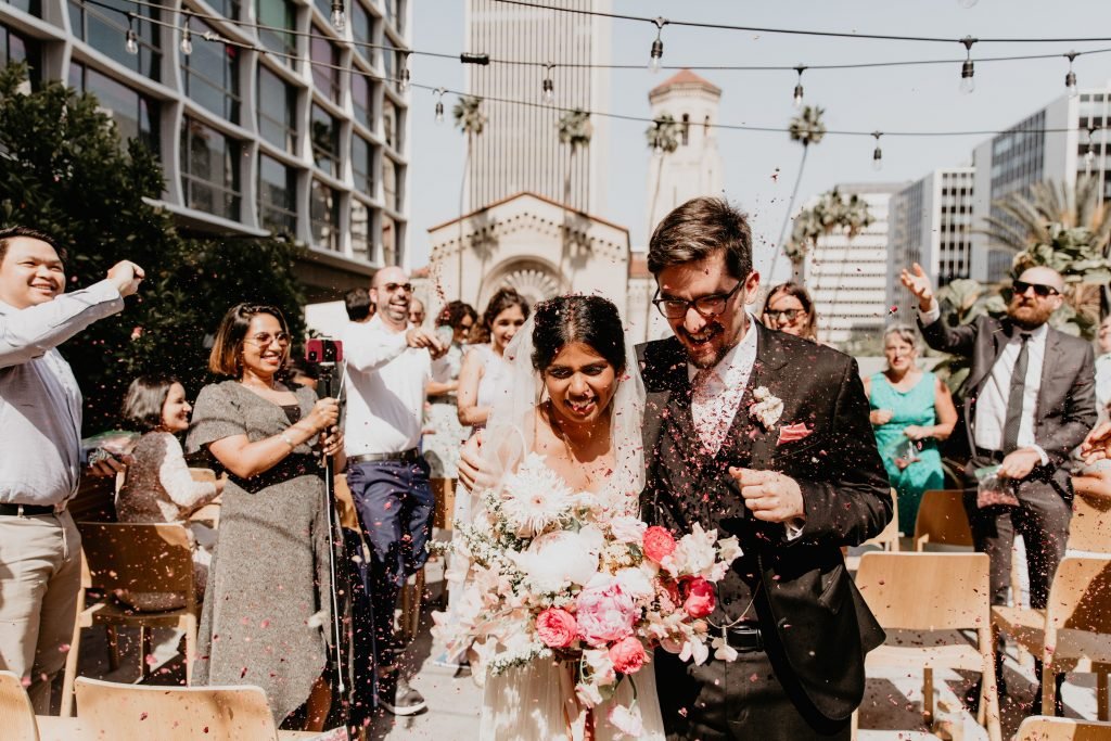 bride and groom just pronounced husband and wife after their LA rooftop ceremony 