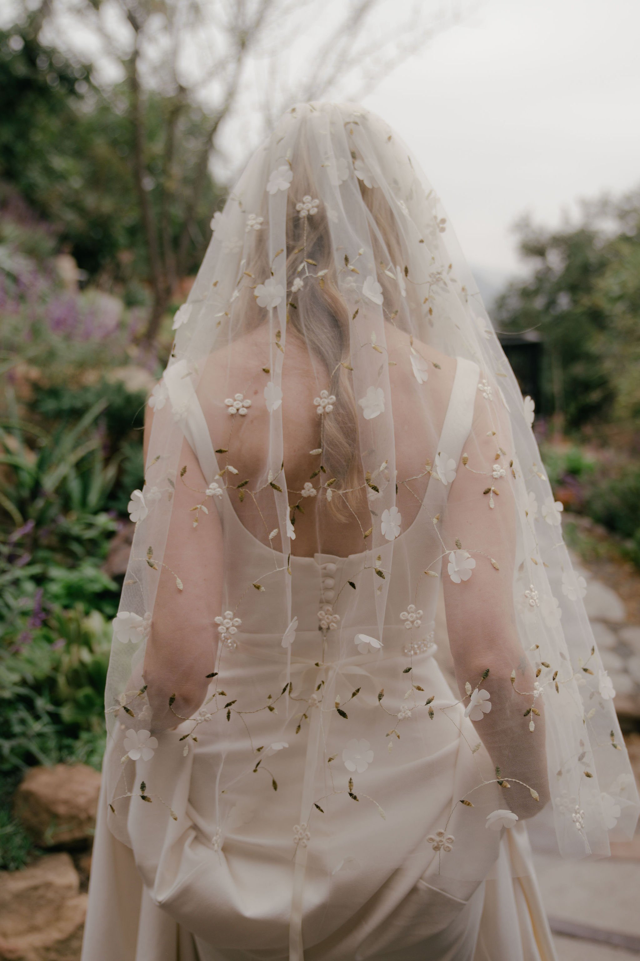 bride wears intricate and detailed floral veil to her oceanside beach wedding in malibu, california