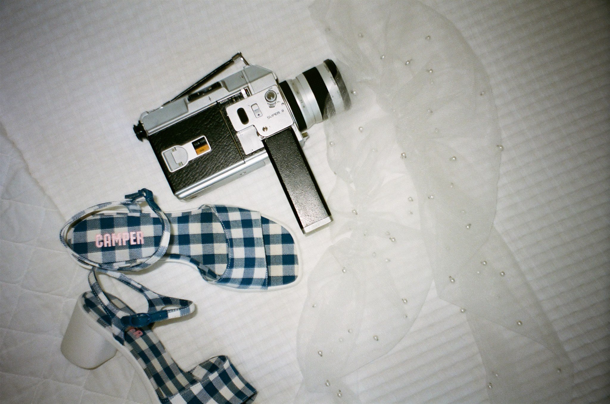 wedding day detail photos with trendy bridal shoes, pearl veil, and super8 camera