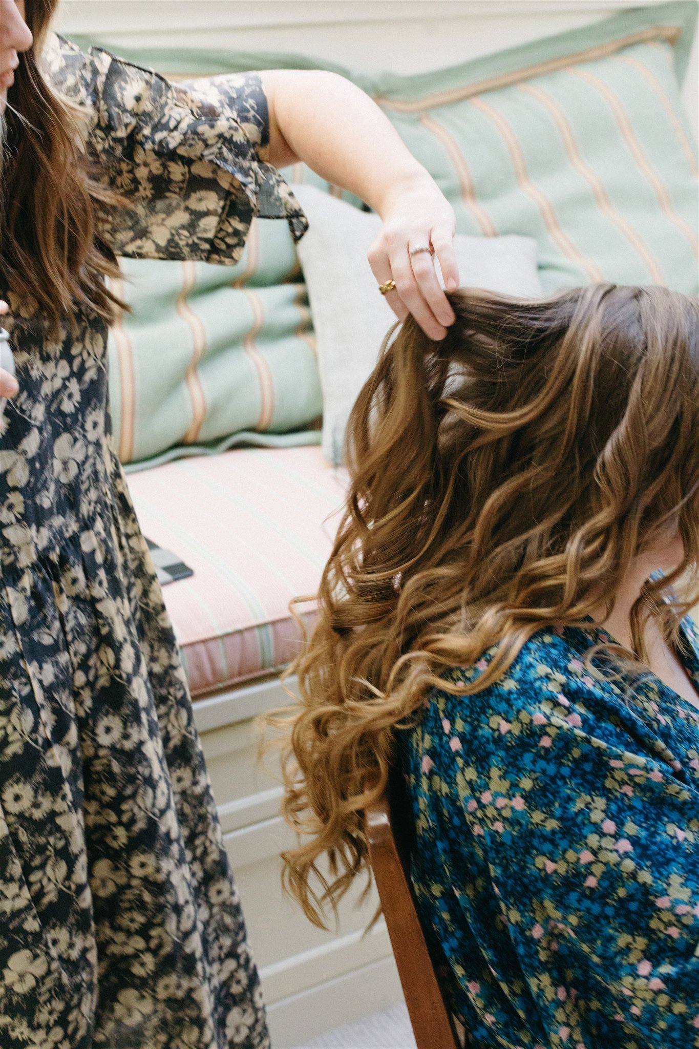 bride in the hair and makeup process on her wedding day morning
