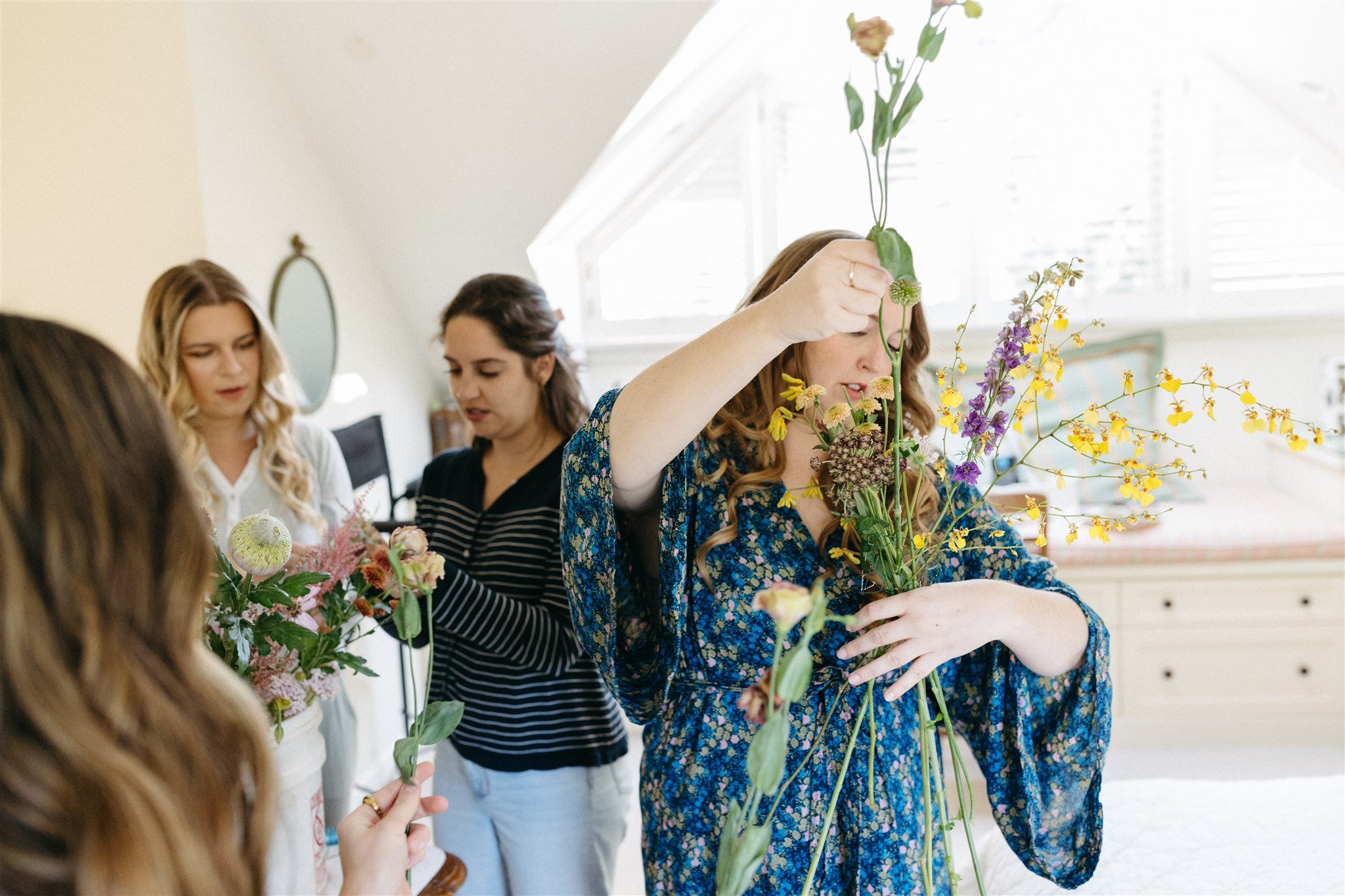 bride puts together her own floral bouquet on the morning of the wedding